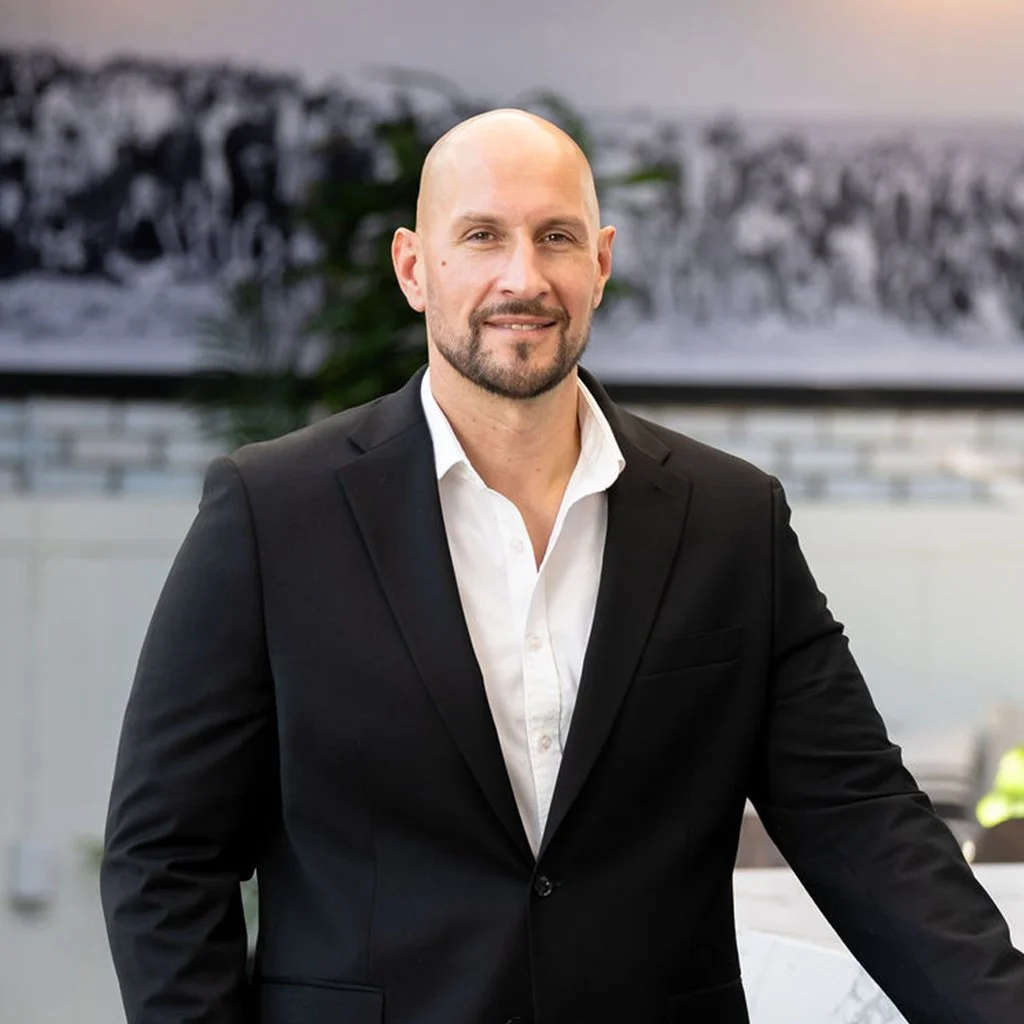 Nesha Korak, Bar Director. A man with a beard in a black suit and white shirt standing on Catch & Cut Rooftop.