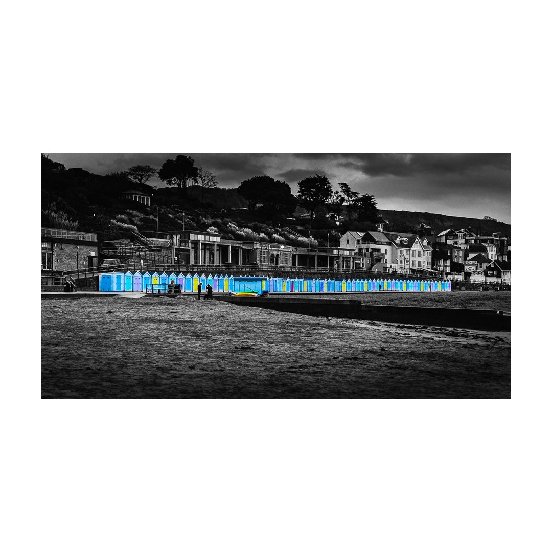 Captured the timeless charm of Lyme Regis, where the vibrancy of the beach huts pops against the moody monochrome backdrop. 🎨🌊 Each shot tells a story, and this one whispers of serene winter mornings by the sea. What's your favourite seaside memory