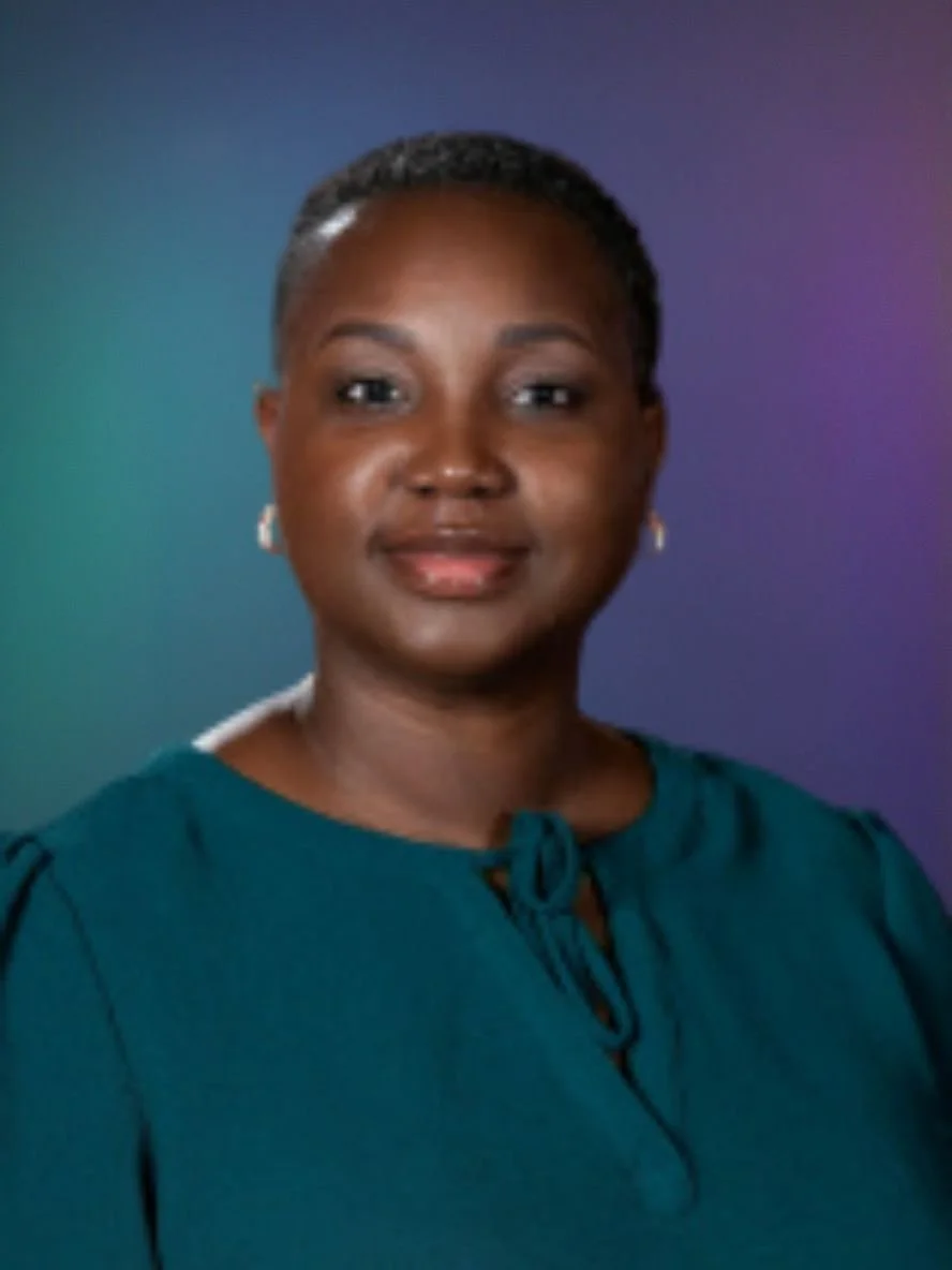 A portrait of a woman with short hair, wearing earrings and a teal blouse with a tied neckline, set against a gradient background.
