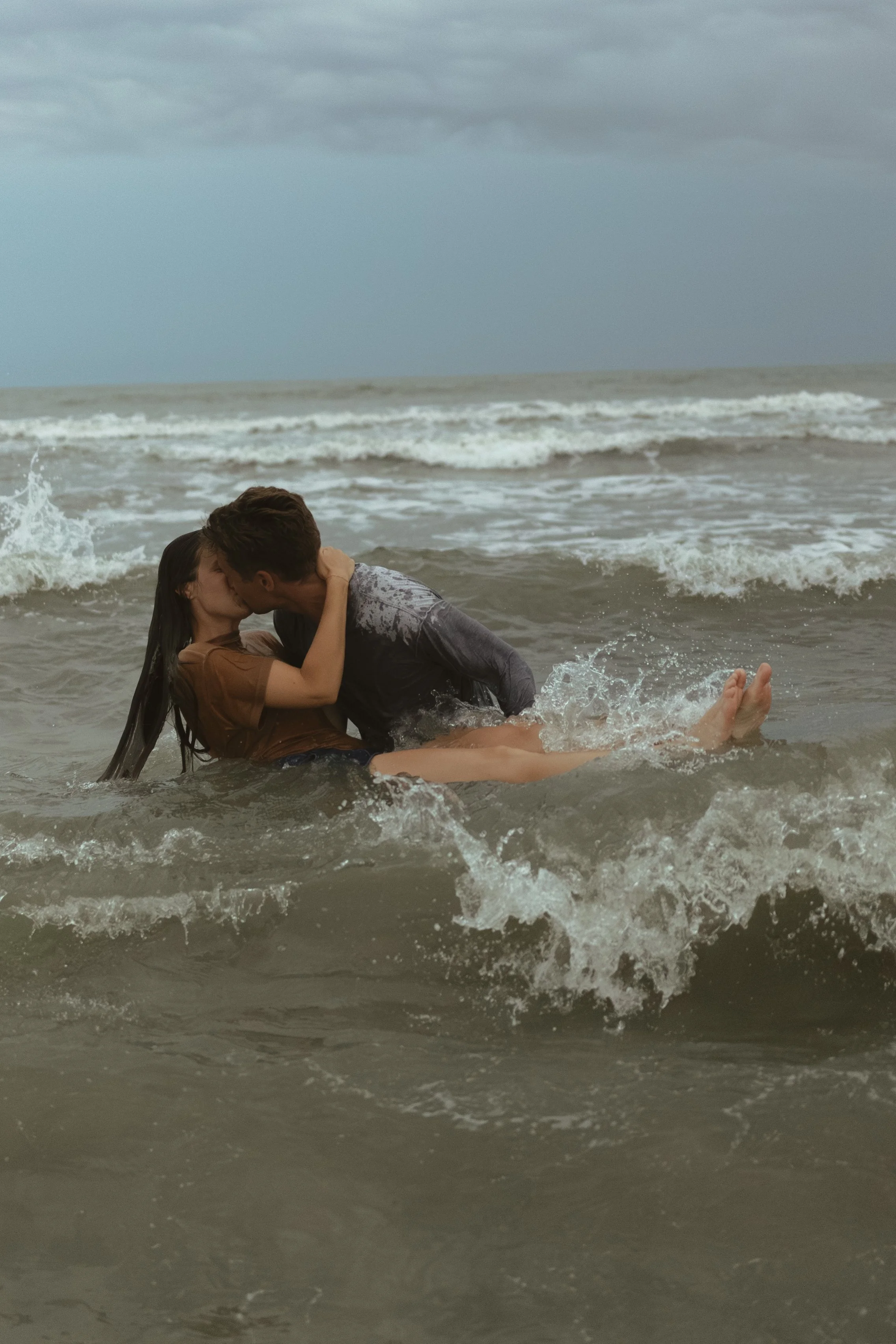 A man and woman sharing an intimate moment, with their foreheads touching, near a window at night.