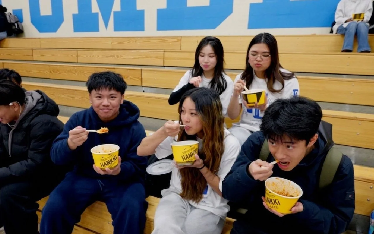 Students eating HANKKi Bowls in the school gym during the HANKKi visit to Father Lacombe High School
