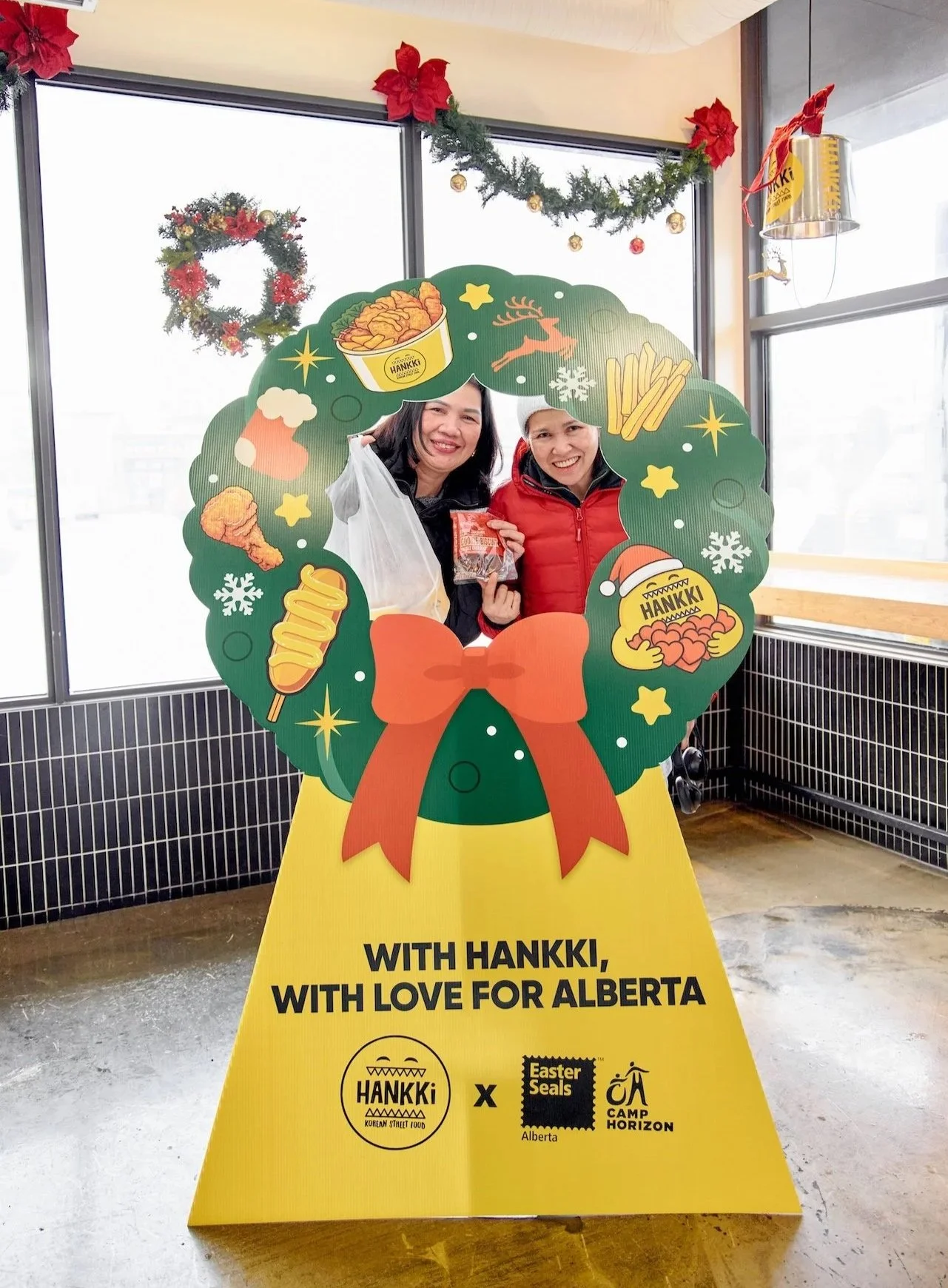 Customers posing at the Giving Back the Love photo zone during Hankki Charity Day 2025 in Alberta