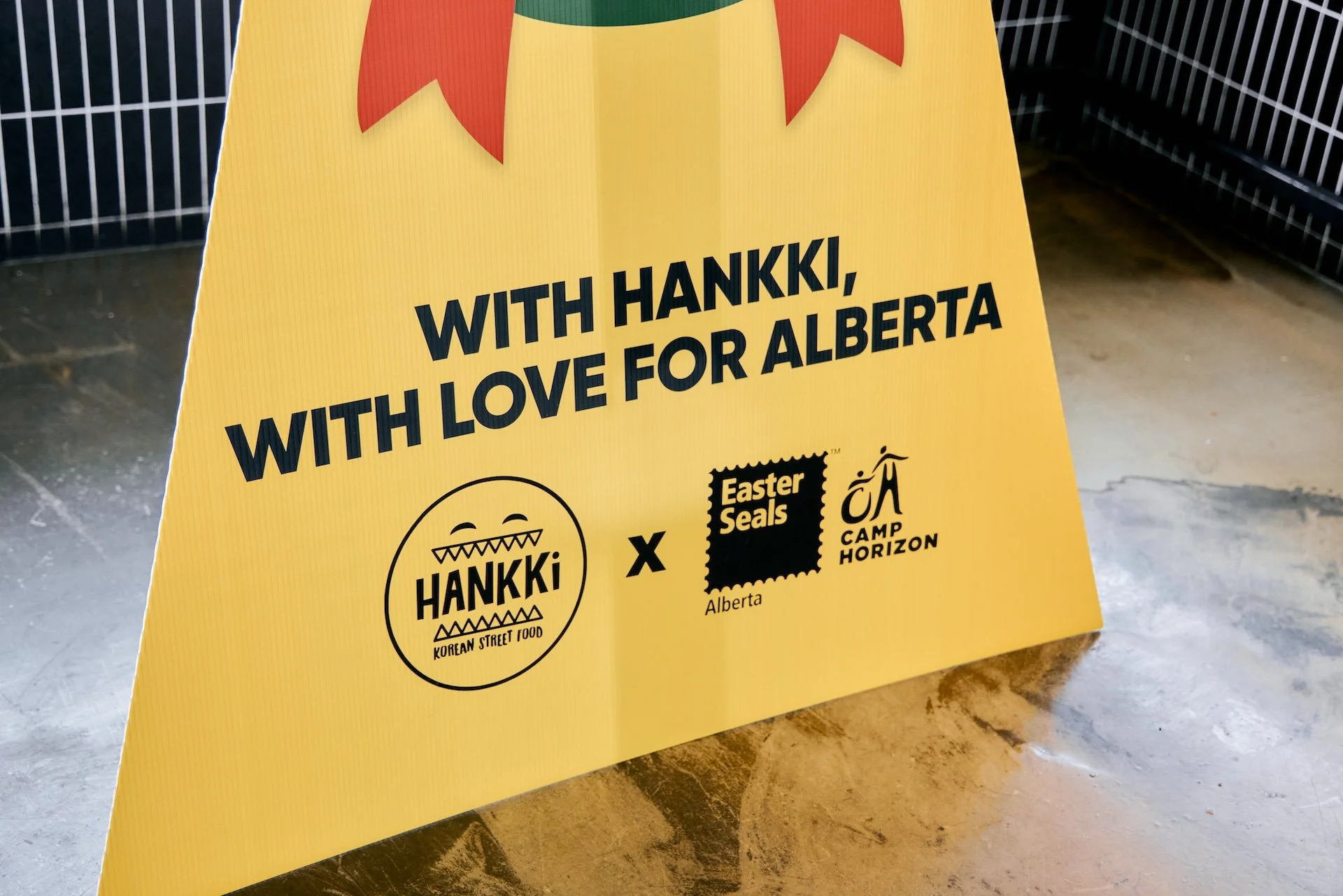 Hankki Charity Day 2025 campaign sign showing partnership with Easter Seals Alberta and Giving Back the Love message