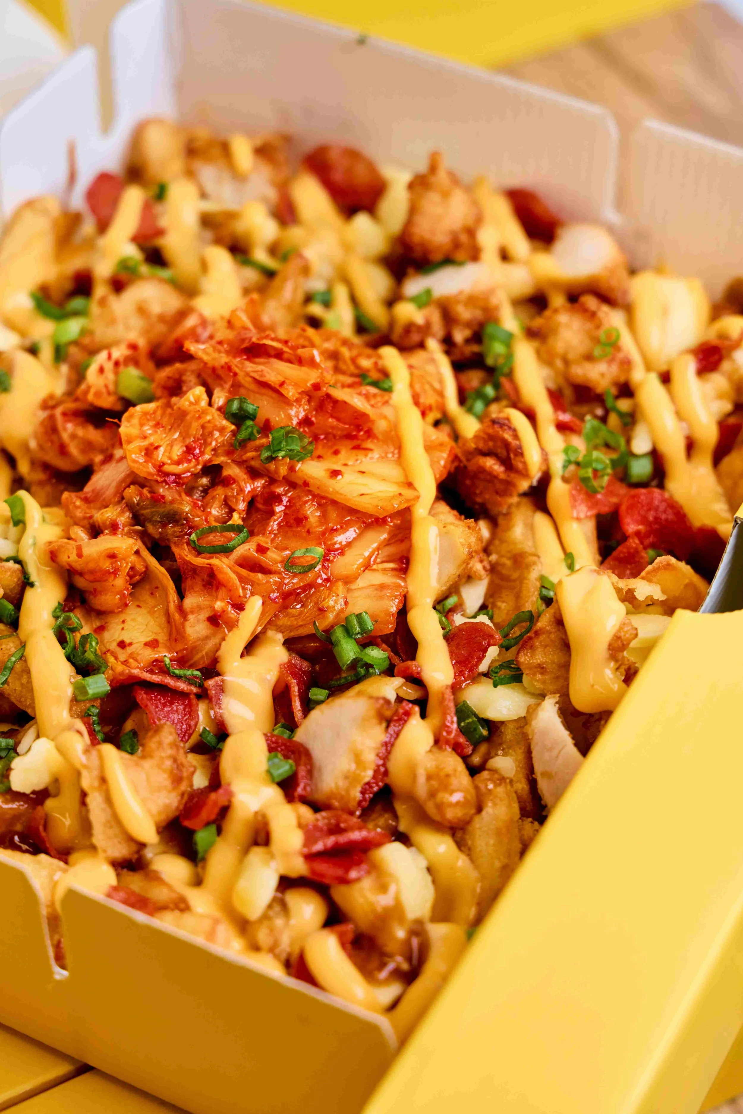 Close-up of HANKKi Seoul Stampede Fries with kimchi, chicken, sausage and cheese sauce