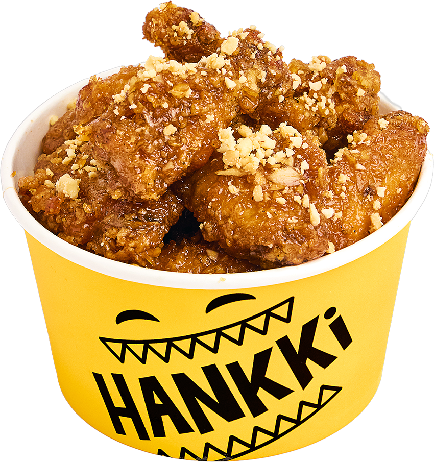 A yellow container of fried chicken pieces topped with crushed peanuts and branded with the Hank's logo.
