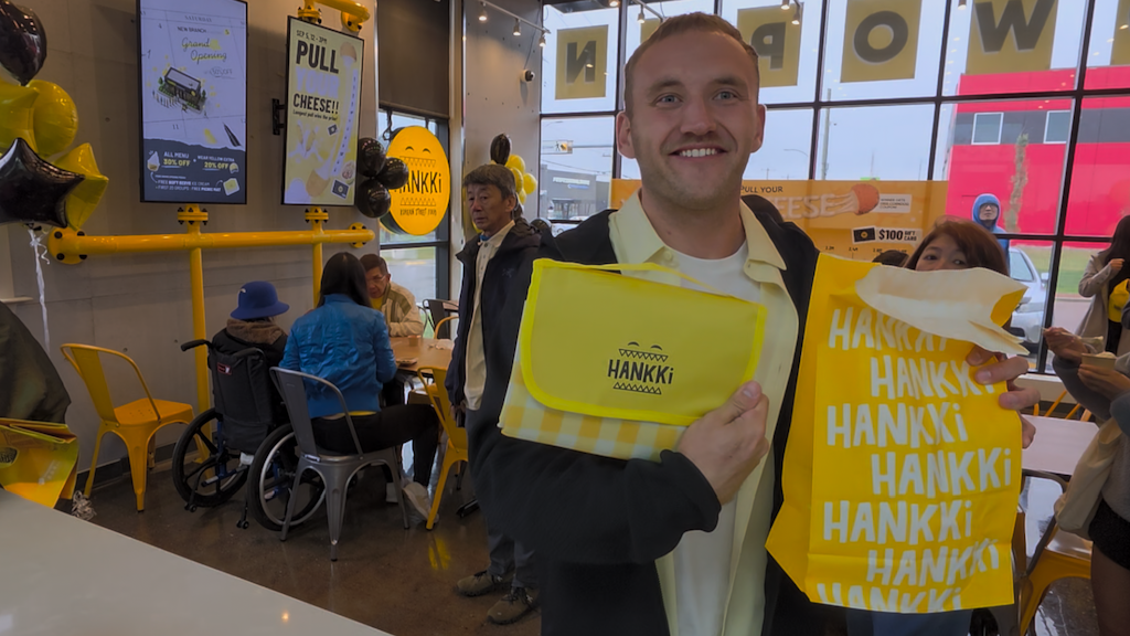 Guest receiving a HANKKi giveaway during the Highfield grand opening celebration