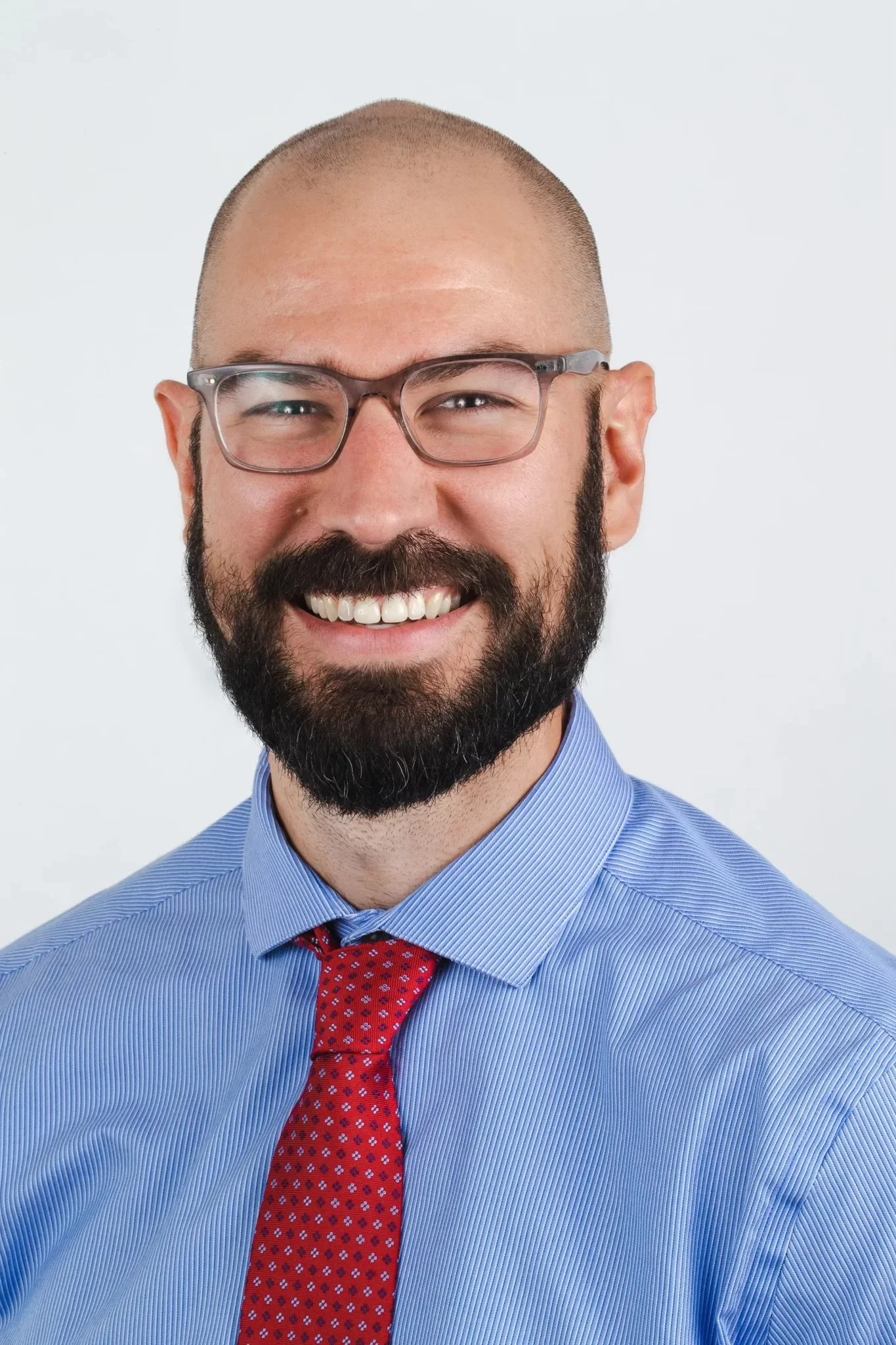 Headshot of Dr. Robert Adams smiling with glasses and a beard wearing a blue dress shirt and red tie.