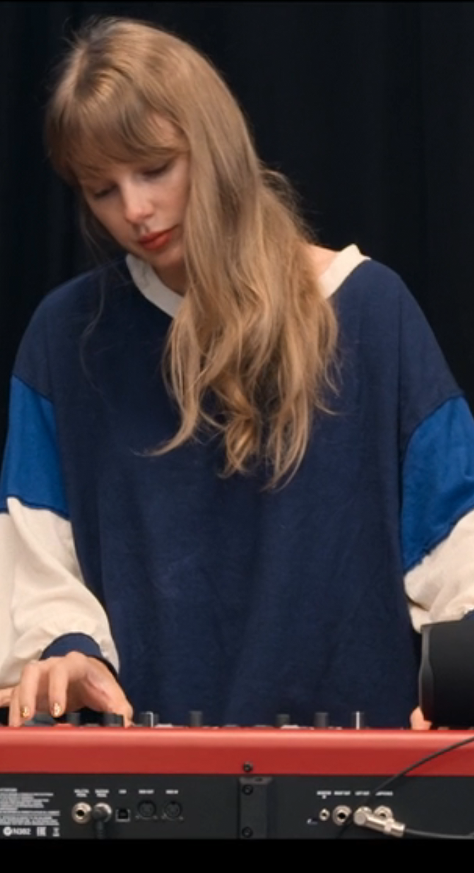 Taylor Swift backstage at the Eras Tour in her Disney+ docuseries The End of an Era wearing a Free People colorblocked sweater.