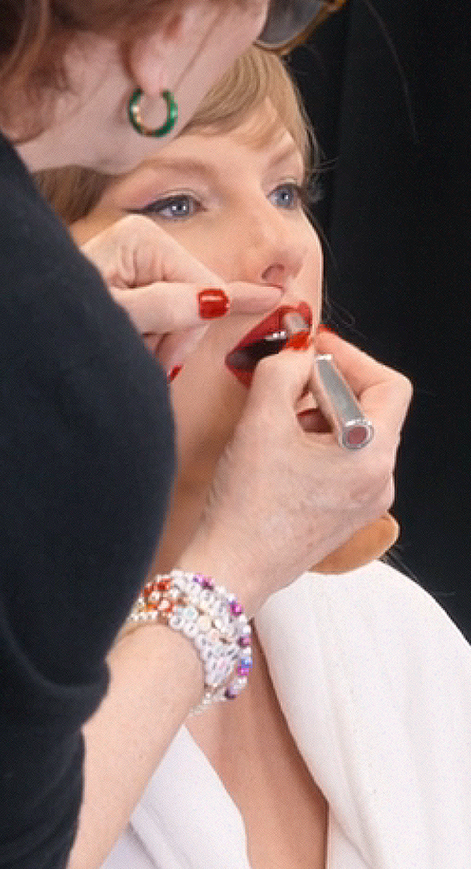 Taylor Swift's makeup artist Lorrie Turk applies red lipstick by MAC on the Eras Tour. Taylor Swift iconic Eras Tour red lipstick revealed.