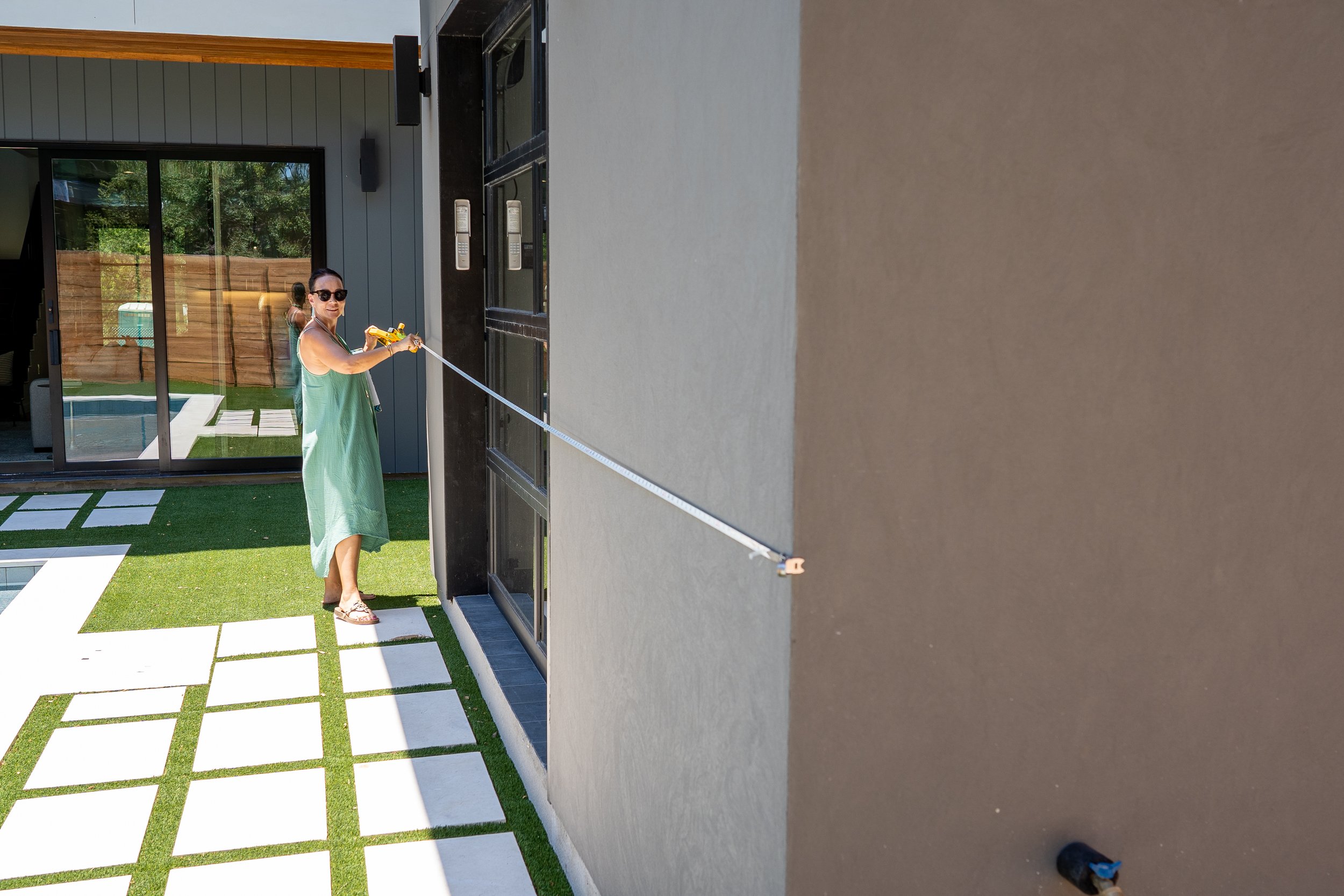 Diana Roberts measuring an exterior wall during a property analysis