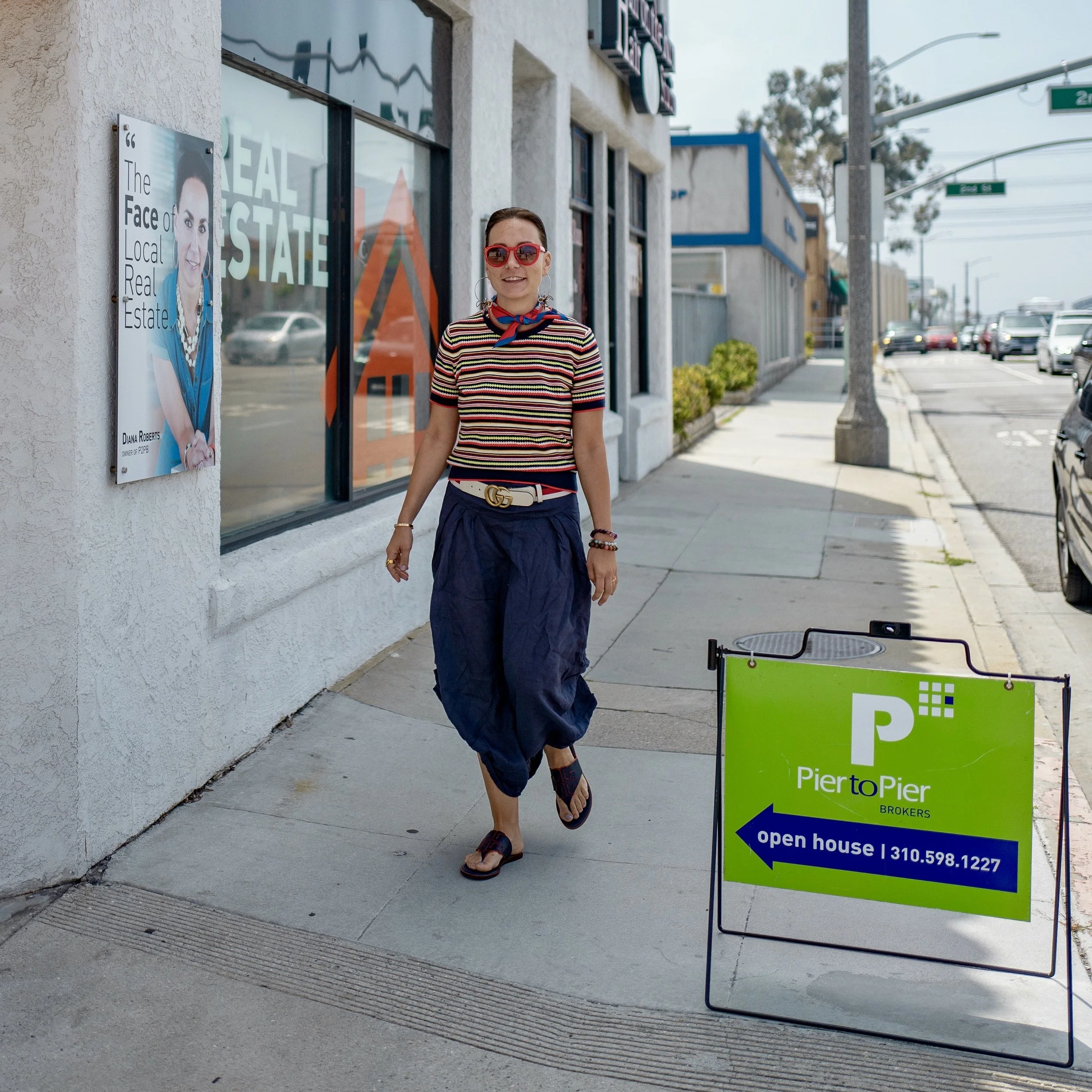 Diana Roberts walking beside an open house sign during her real estate career