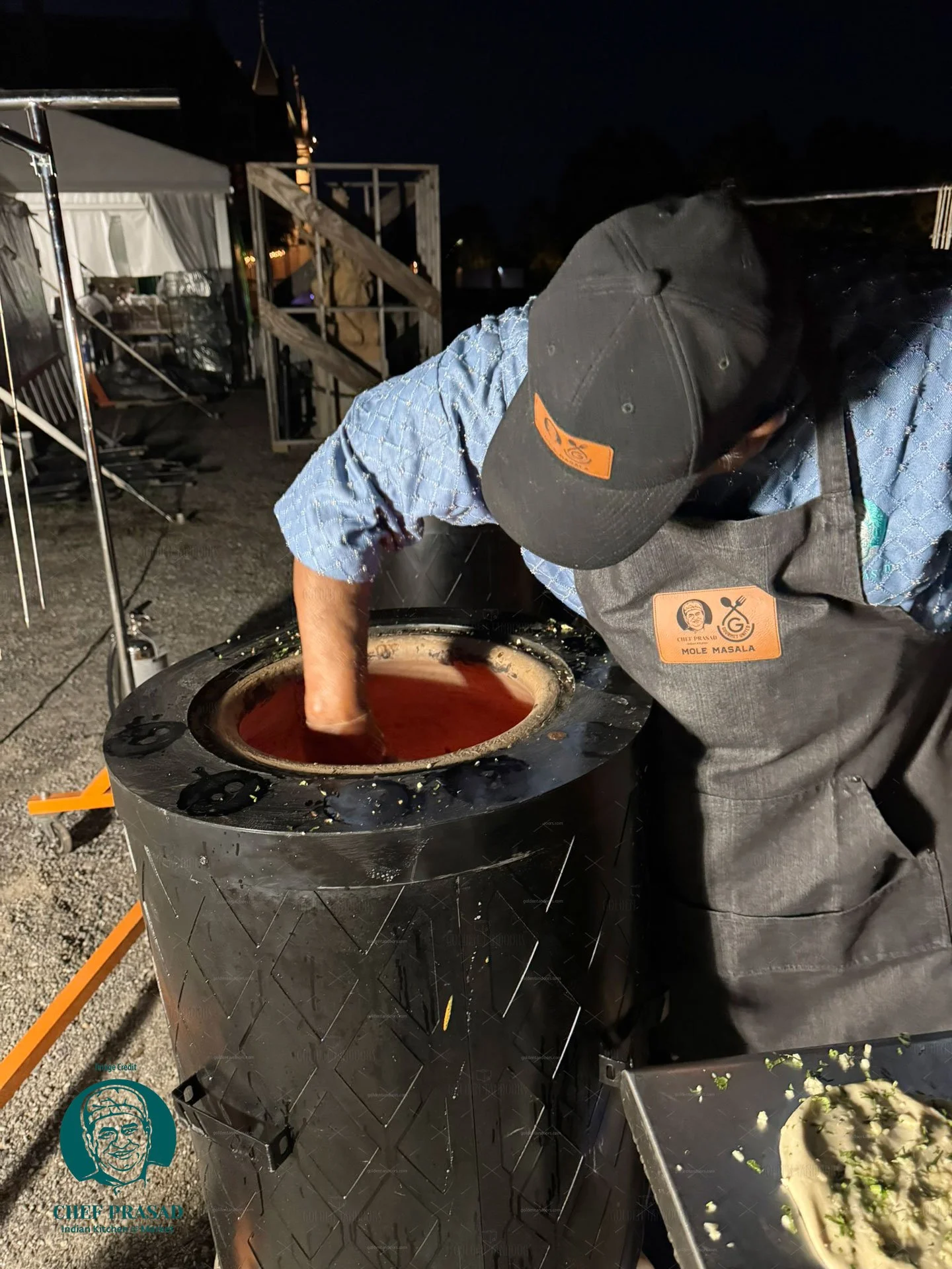 chef putting bread in designer catering tandoor oven