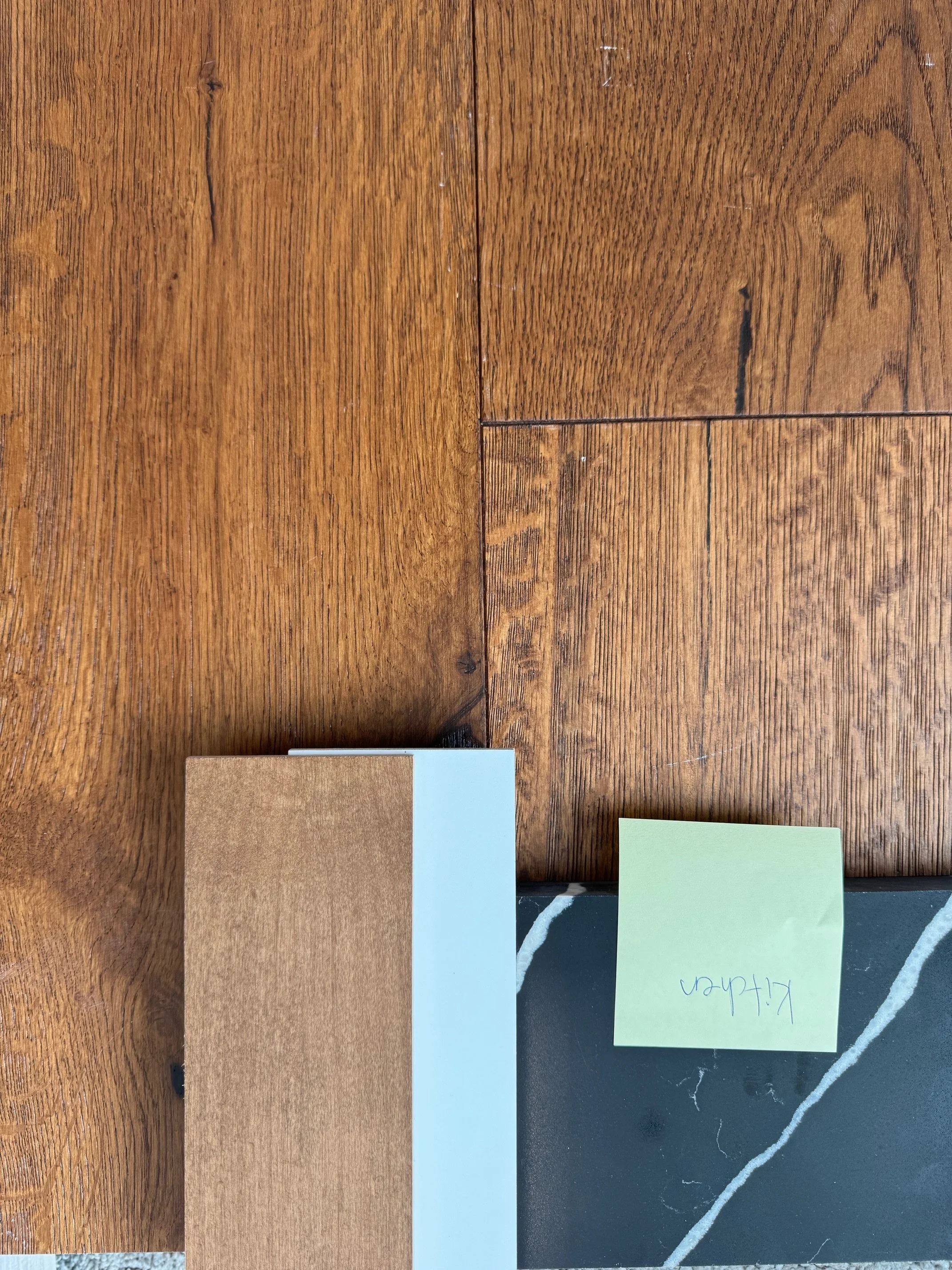 Wooden floor with a small blackboard and a sticky note that reads 'kitchen'.