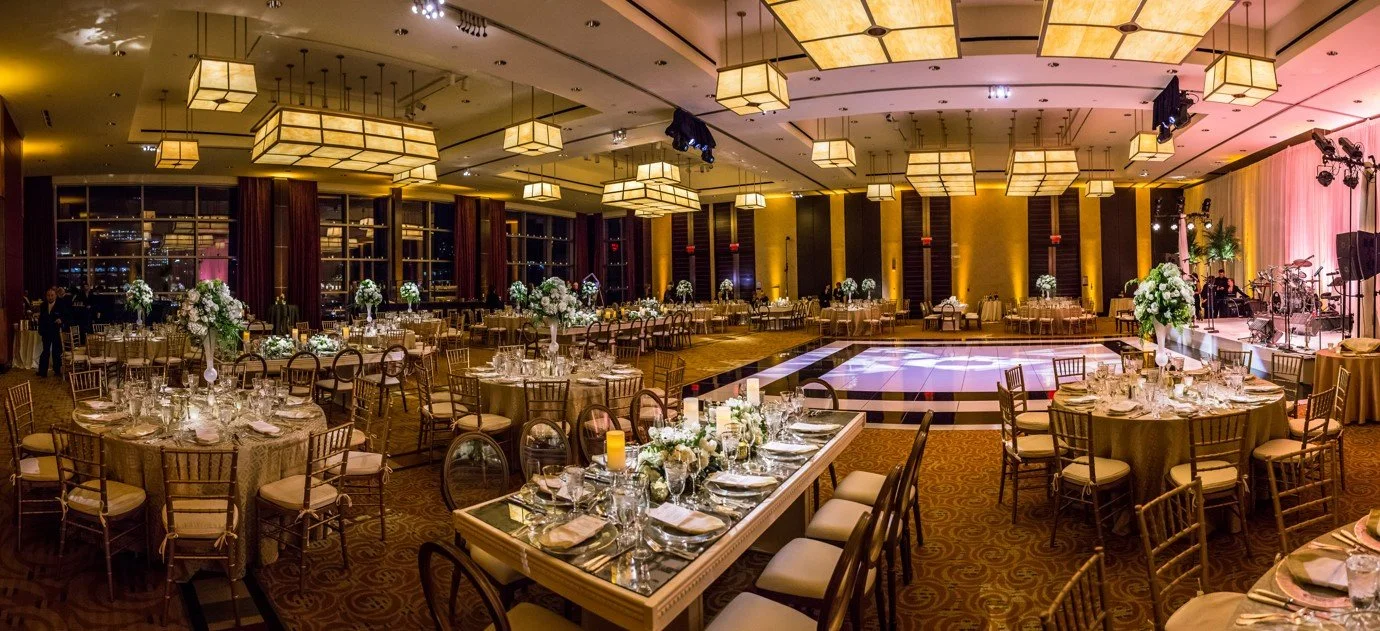 Ballroom reception with lantern chandeliers, long and round tables, and a checkered dance floor, showing the detail an experienced event planner manages