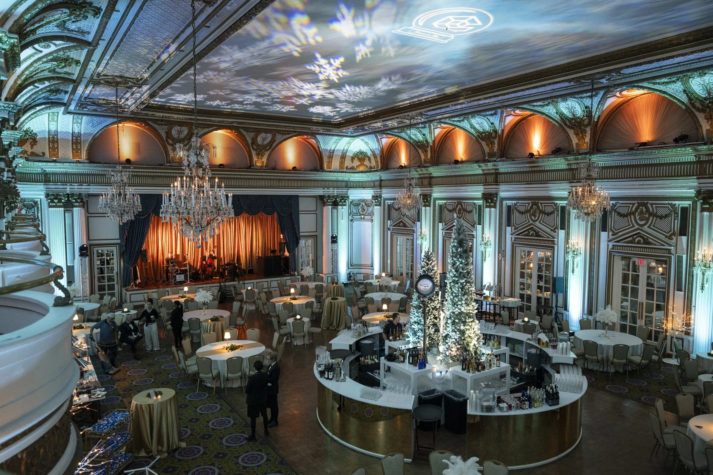 Fairmont Copley ballroom in Boston with snowflake gobos across the ceiling and teal uplighting for a winter corporate holiday party by Siagel Productions