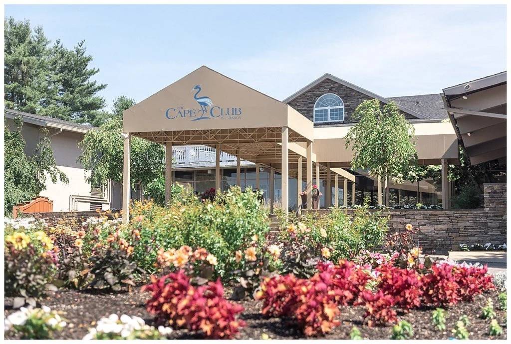 The Cape Club of Sharon clubhouse entrance with its covered walkway and flower gardens, a country club wedding and event venue in Sharon, MA