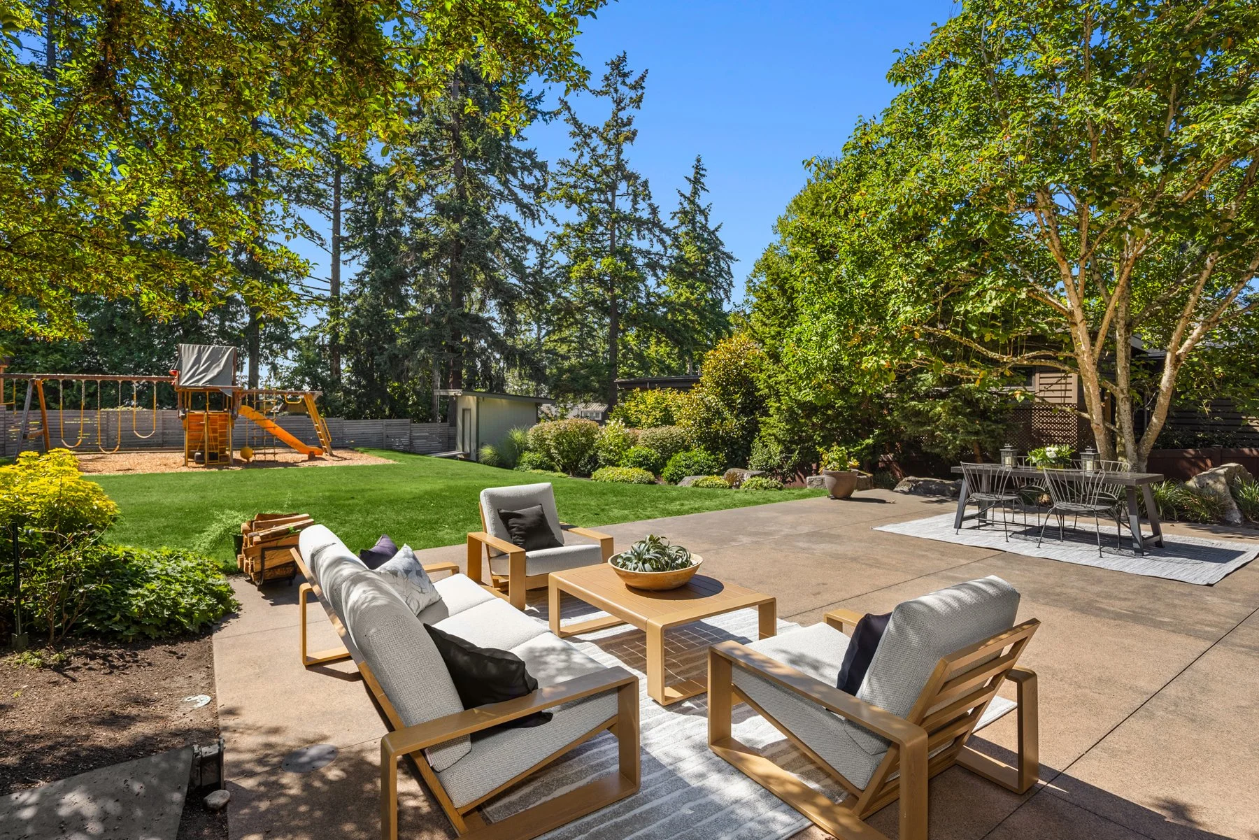 Meticulous gardens and yard surround the patio and home