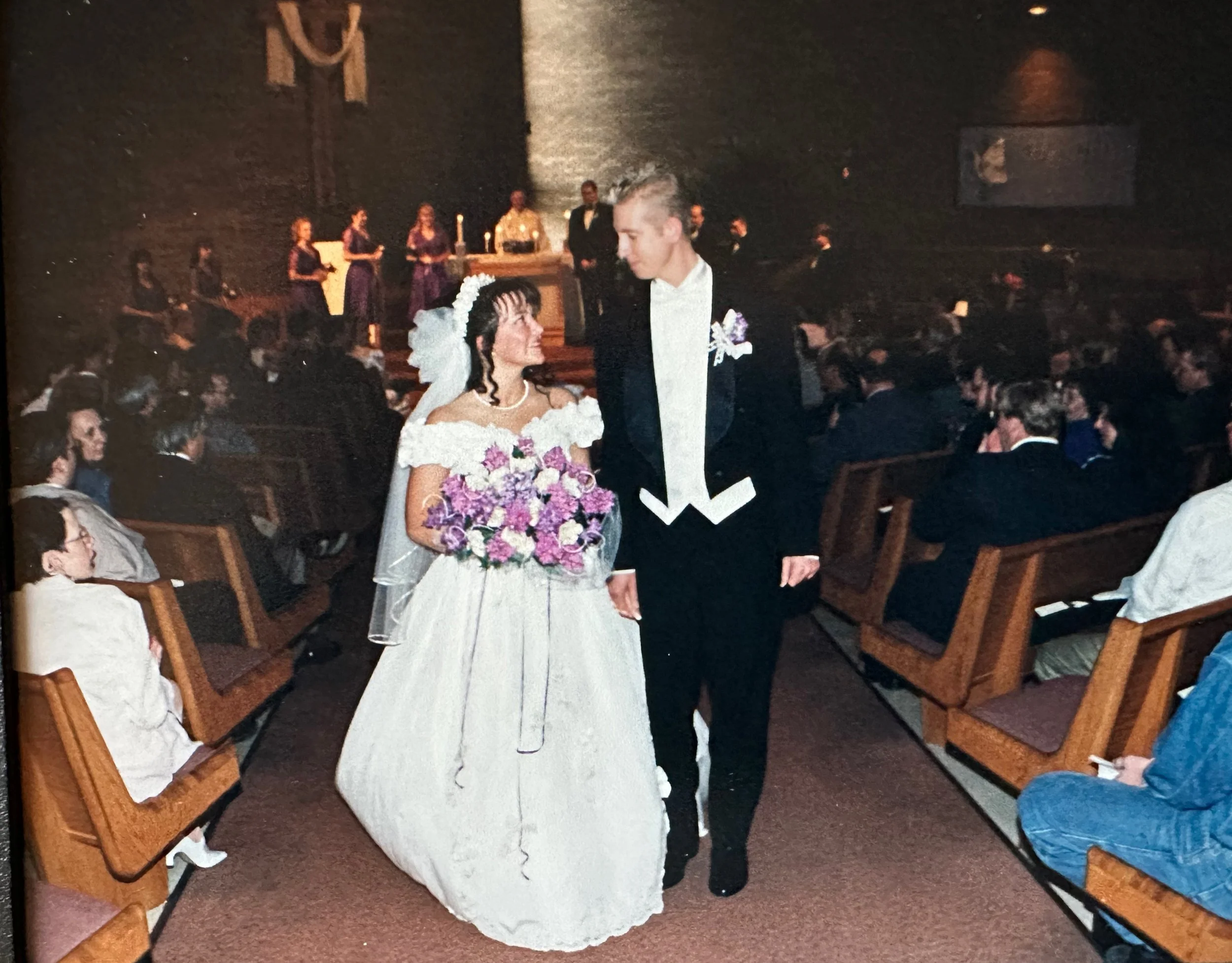 Jeni and Tim look at each other as they head down the aisle after saying "I do" nearly 30 years ago.