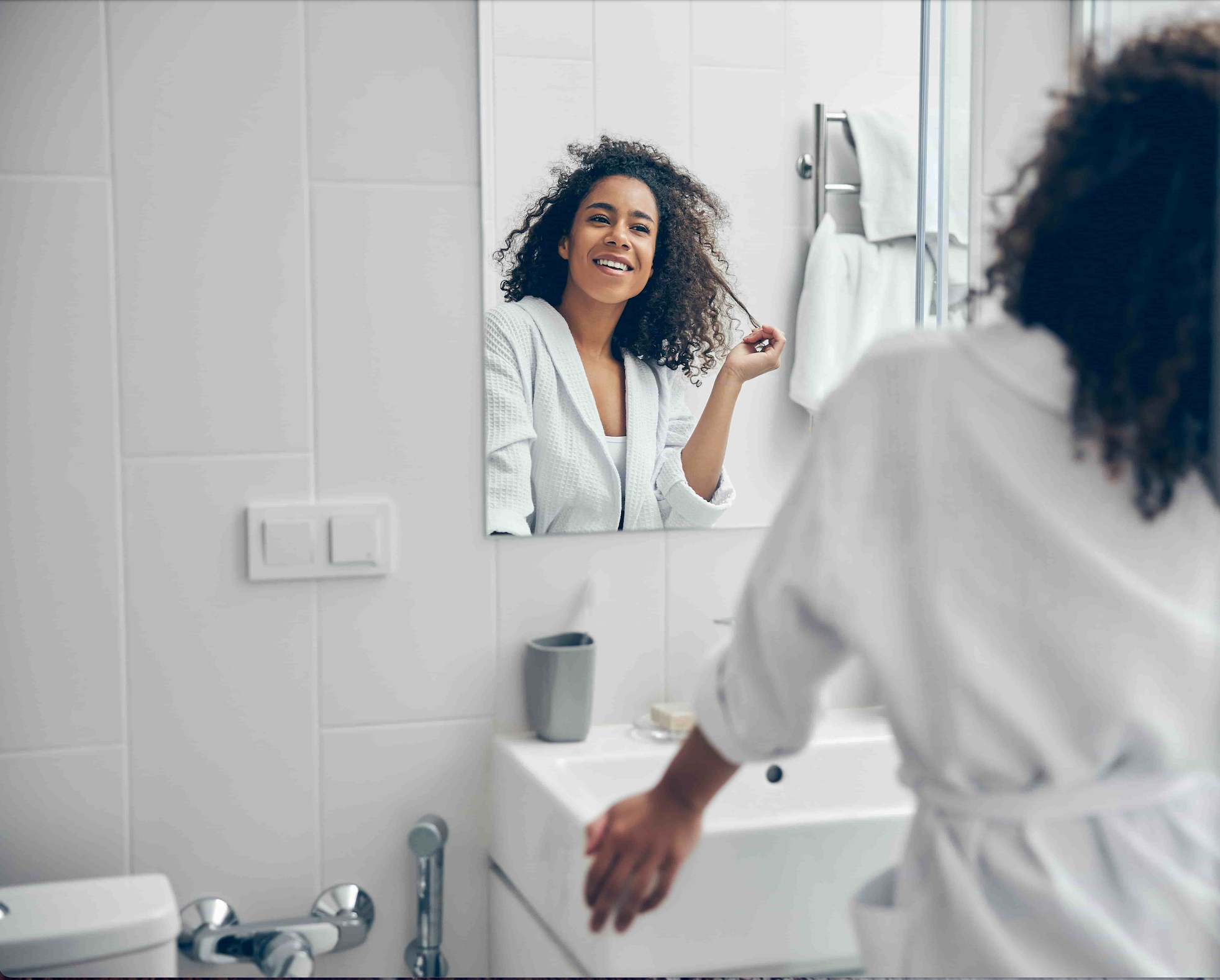 A woman confidently looking at herself in the mirror, thanks to distorted eating and body image therapy with Dr. Perrine in Tampa.