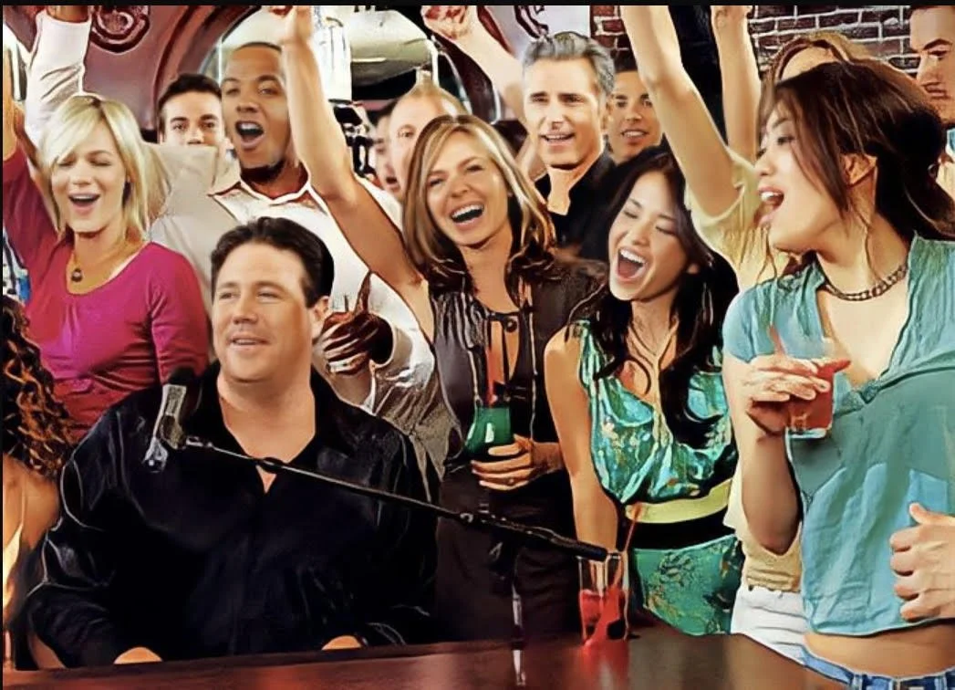 A lively group of friends celebrating at a bar, singing, dancing, and enjoying drinks.
