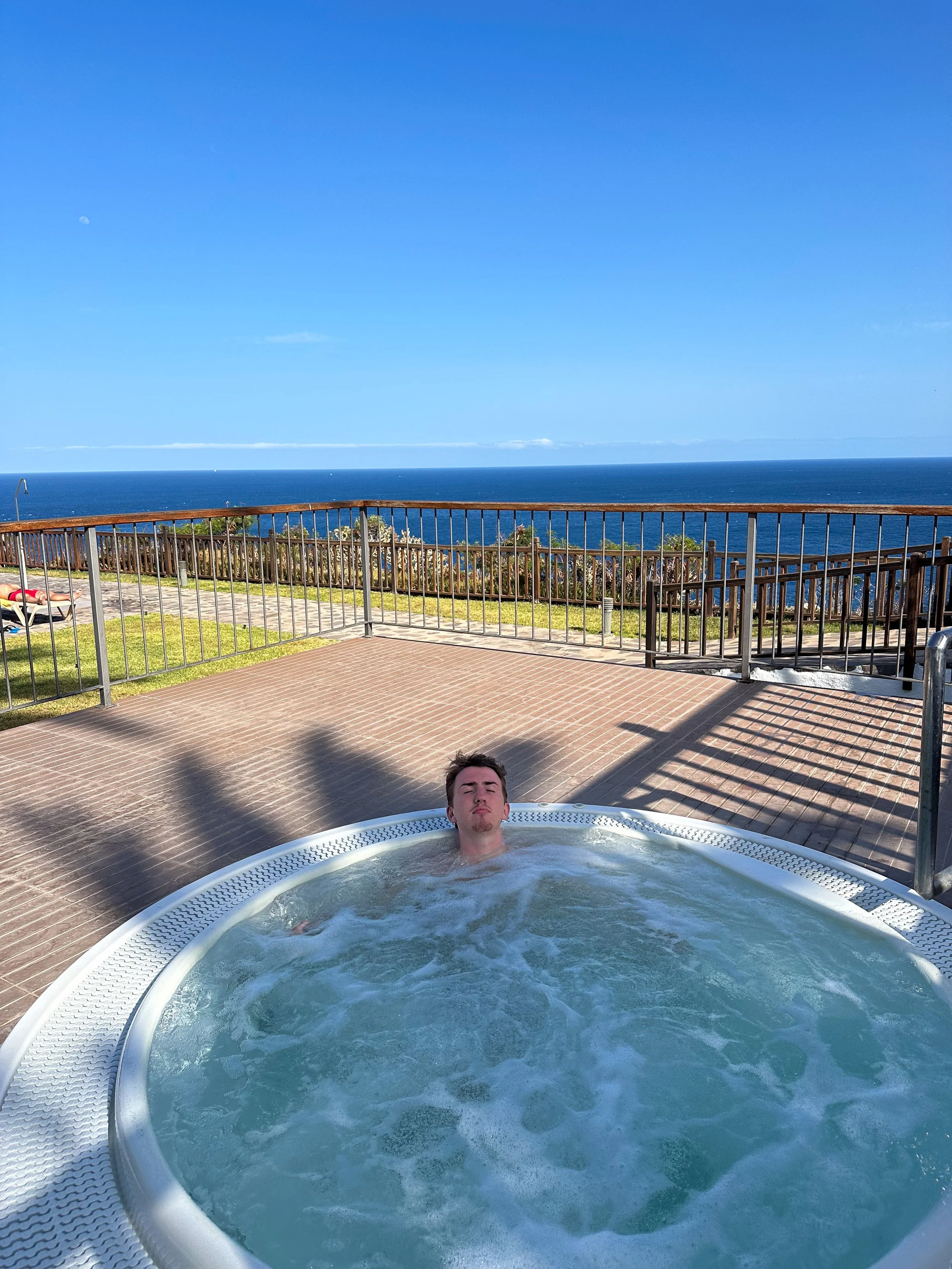 Max in the jacuzzi of Parador La Gomera with the ocean behind.jpg