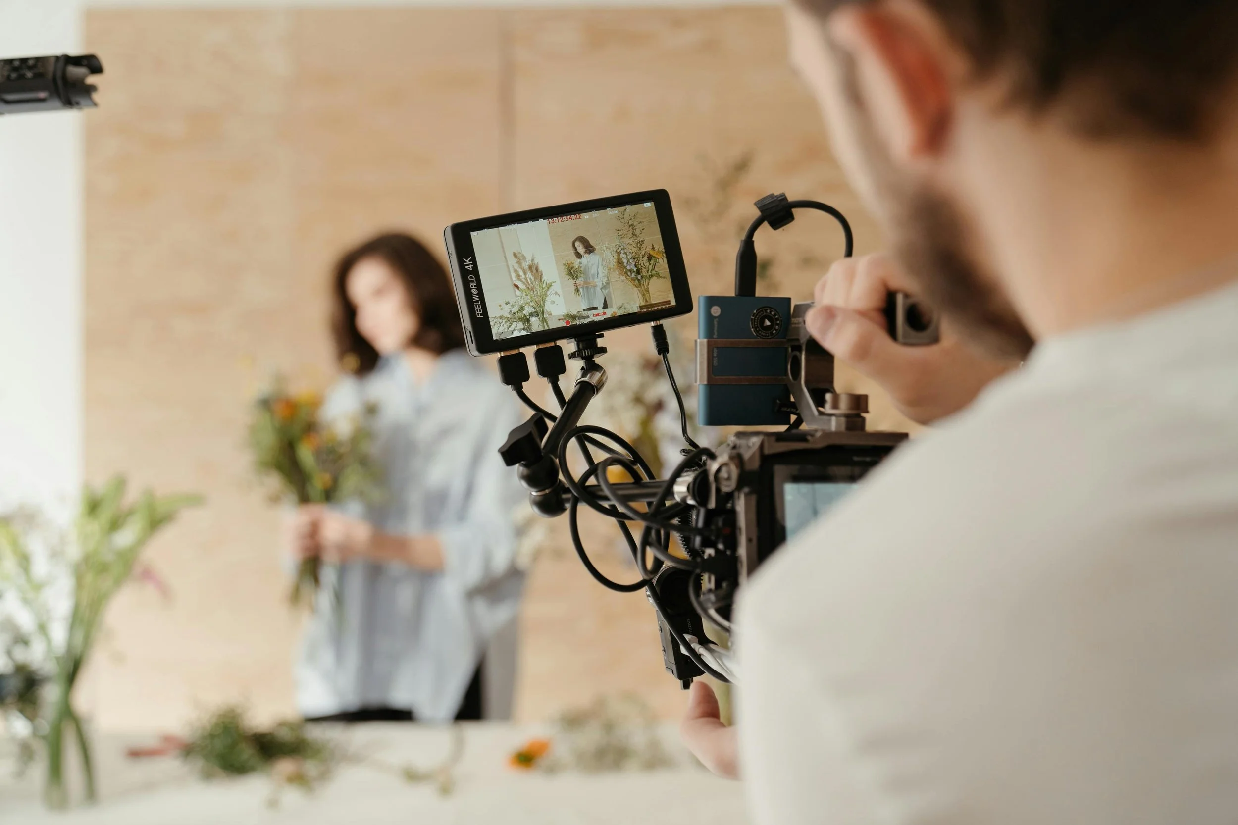 Two people sitting at a table in front of a camera giving an interview.