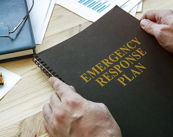 Man holding binder with "emergency response plan" text across front