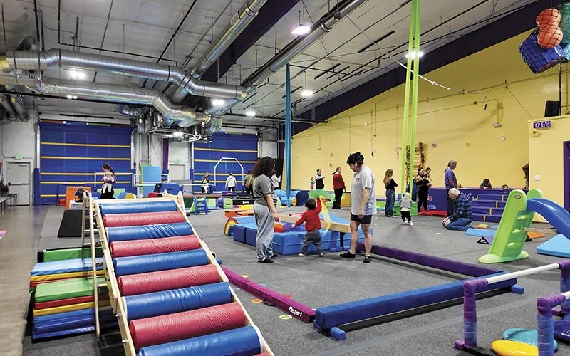 Mothers playing with their young babies on a soft play set