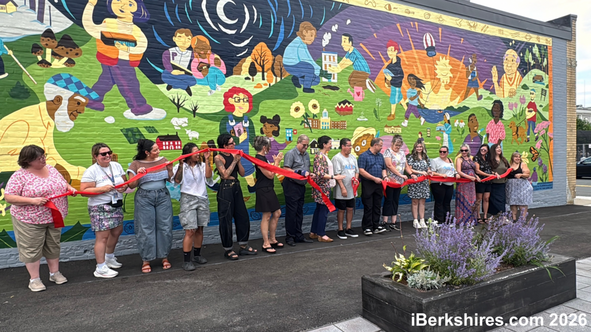 Image of large colorful wall mural with many people standing in front of it for ribbon cutting ceremony