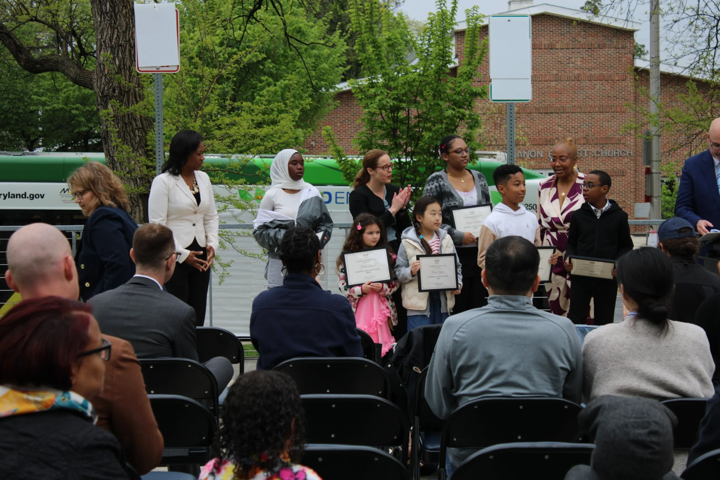 Contest winners stand with awards on parks and people's campus