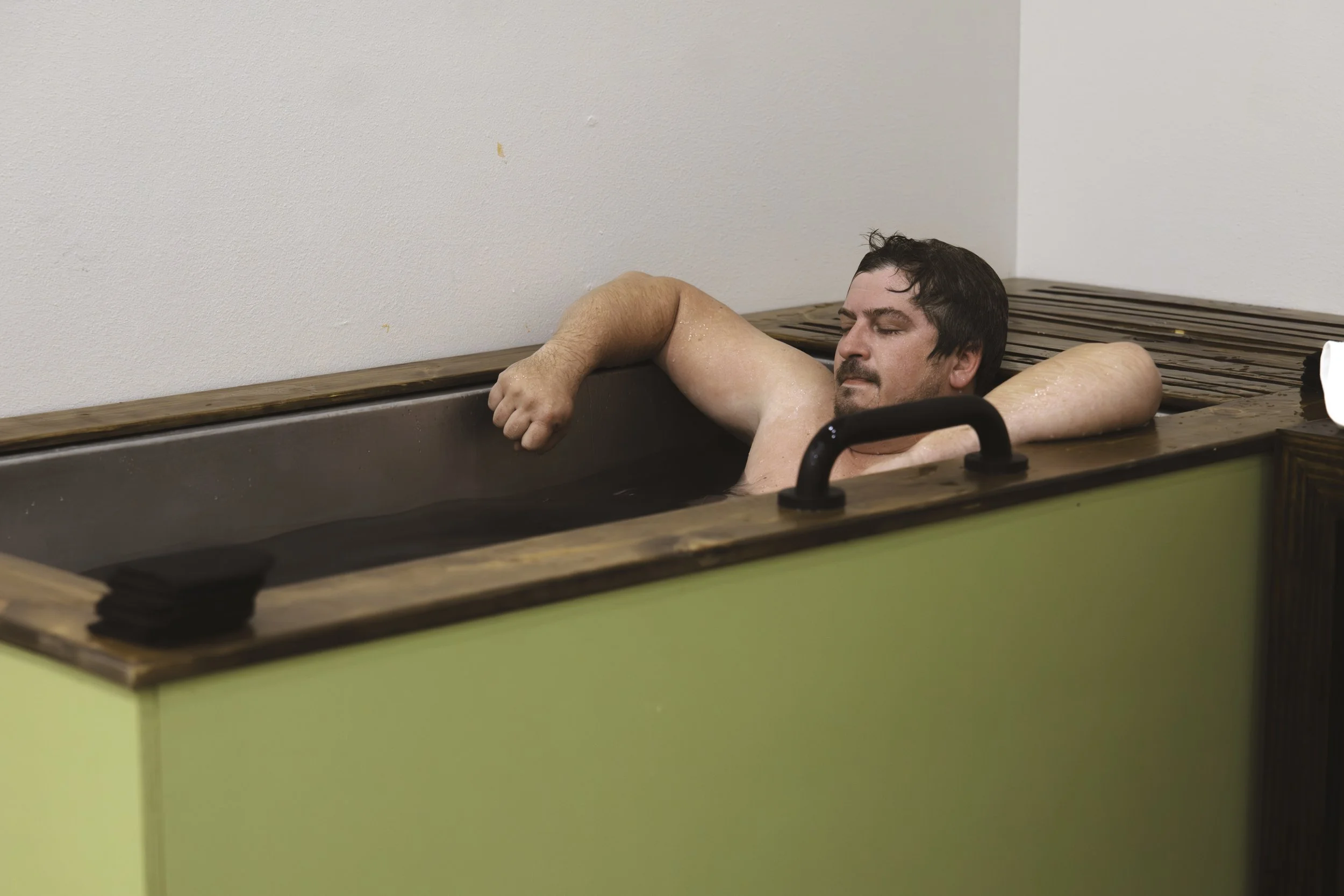 Man in cold plunge looking relaxed.