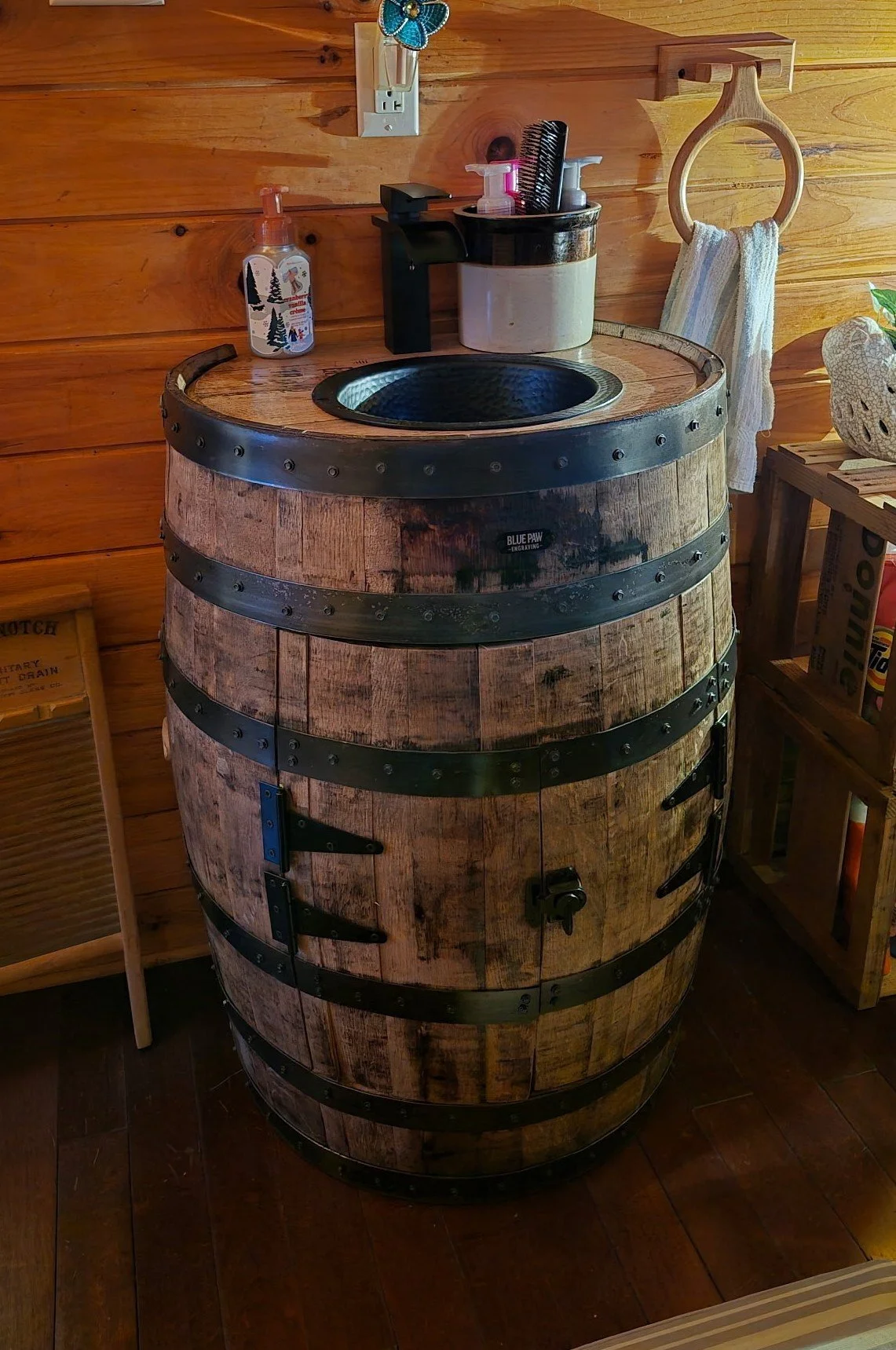 Bathroom sink set into a bourbon barrel with cabinet doors.