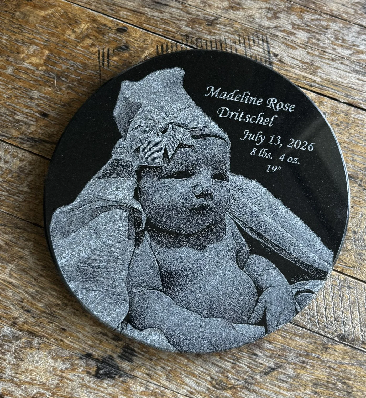 Round granite engraved with newborn baby photo, date of birth and birth weight.