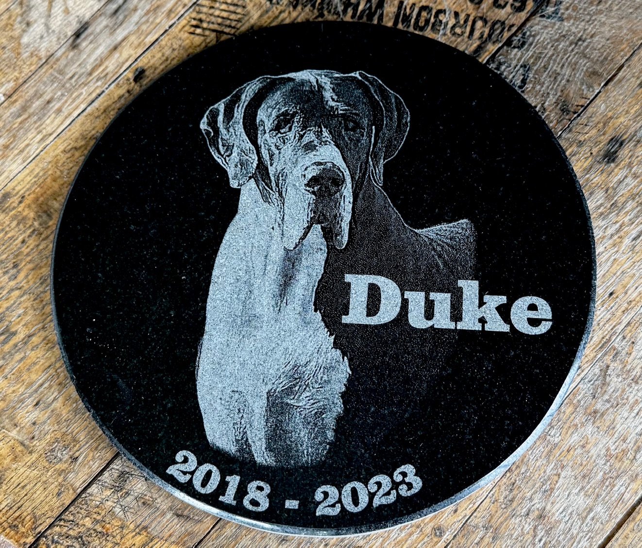 Granite engraved with a portrait of a great dane named Duke with dates of birth and passing