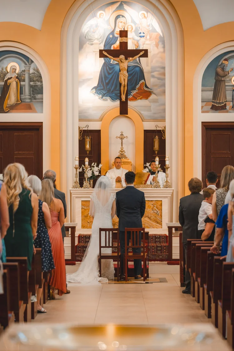 Wedding ceremony photographed from the centre aisle of a church