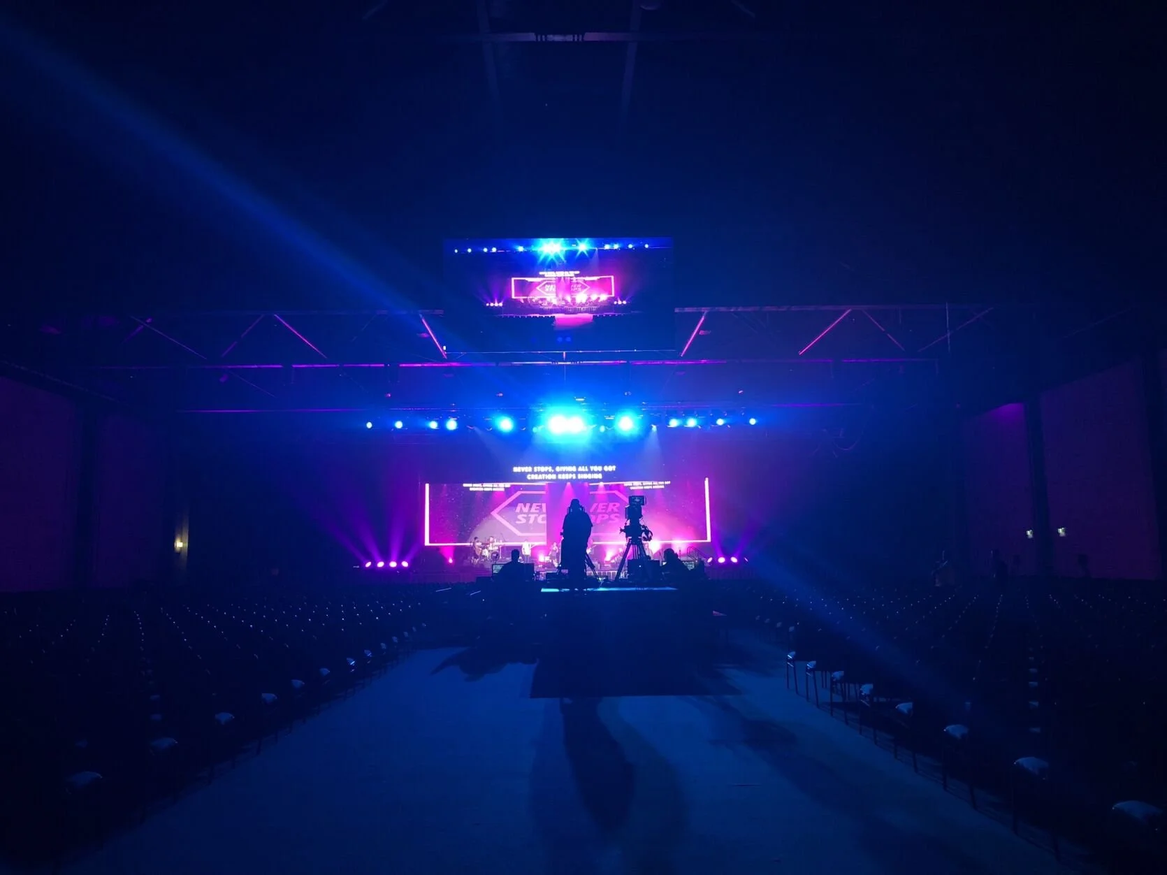Empty concert hall with stage lights and video screen