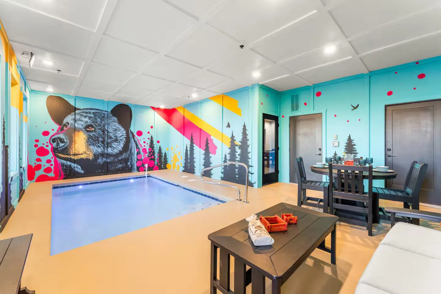 Vibrant pop-art black bear wall mural with forest silhouettes in a Smoky Mountains cabin.