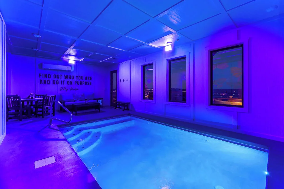 Vibrant neon-style Dolly Parton portrait mural with colorful butterflies in a Sevierville, Tennessee cabin.