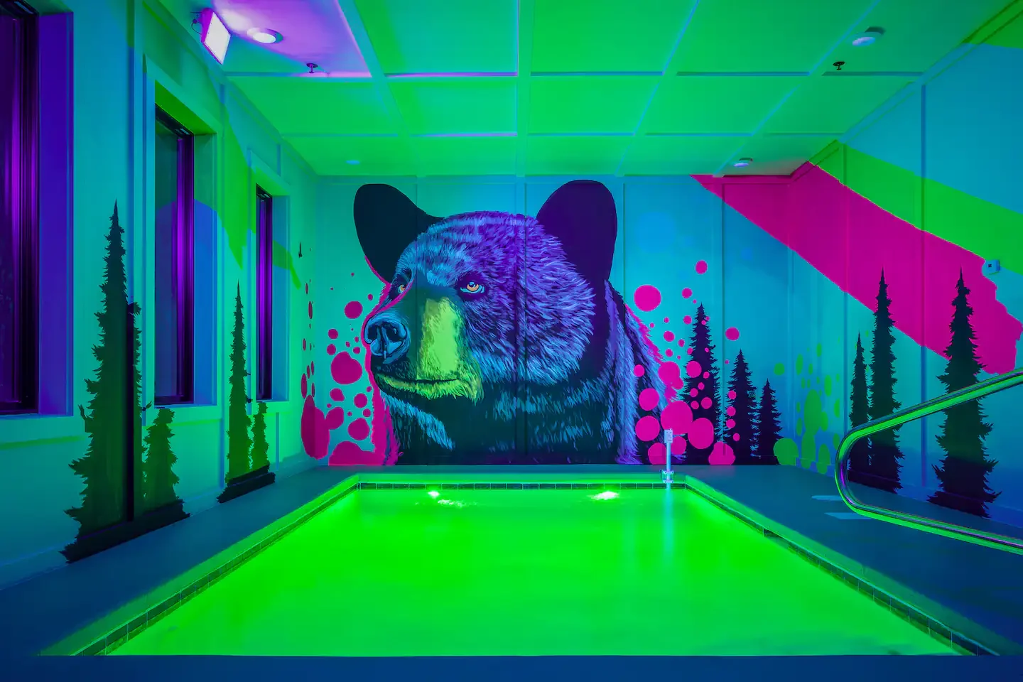 Vibrant pop-art black bear wall mural with forest silhouettes in a Smoky Mountains cabin.