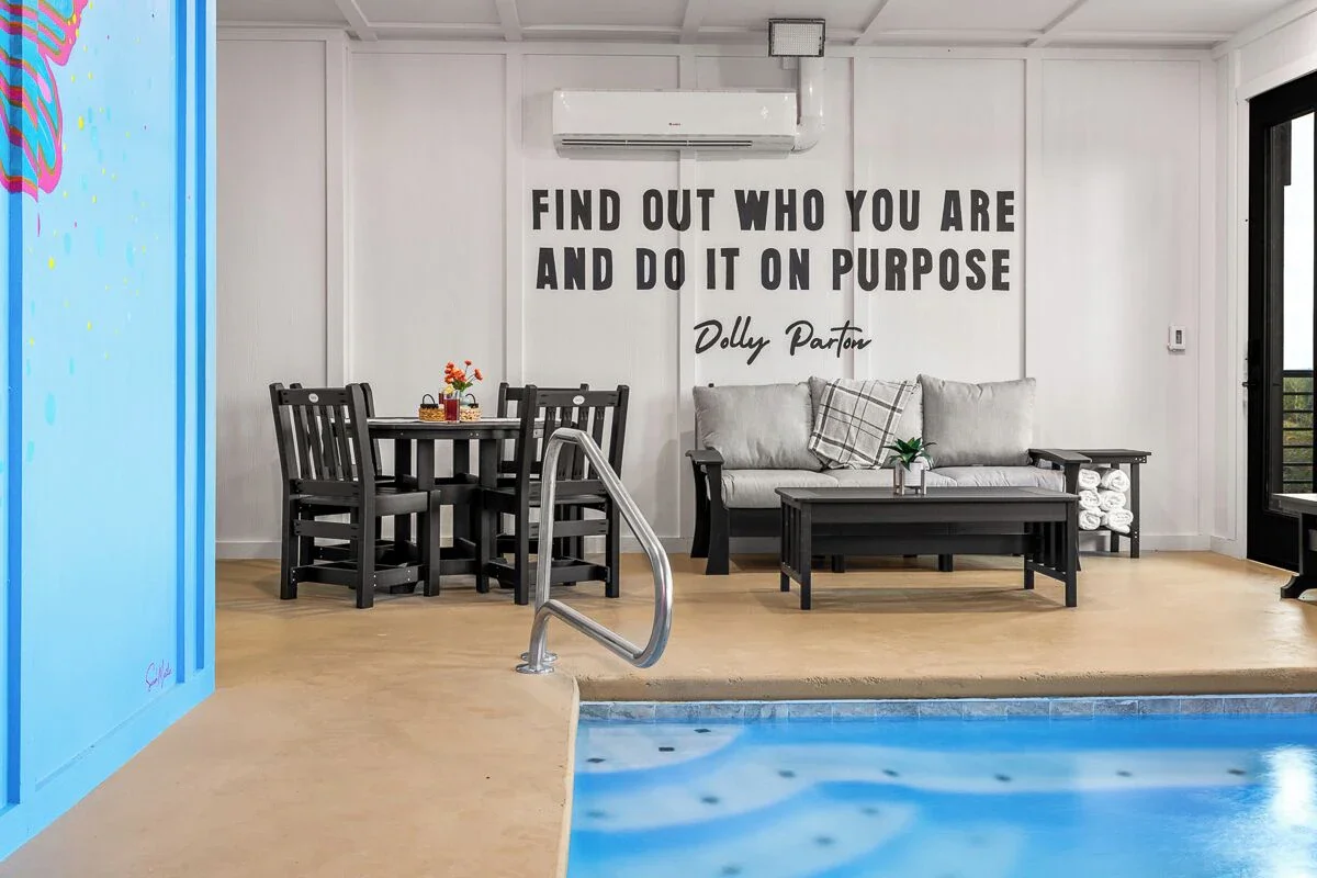 Vibrant neon-style Dolly Parton portrait mural with colorful butterflies in a Sevierville, Tennessee cabin.