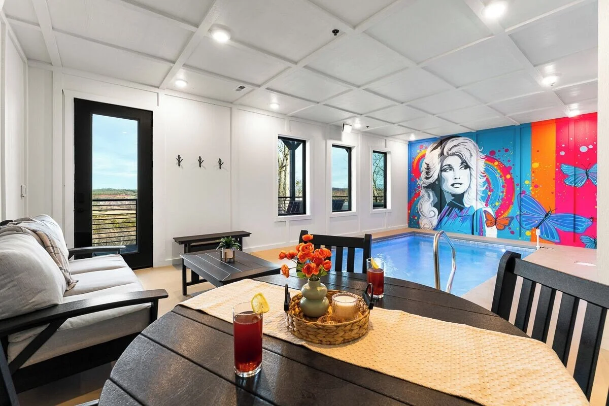 Vibrant neon-style Dolly Parton portrait mural with colorful butterflies in a Sevierville, Tennessee cabin.