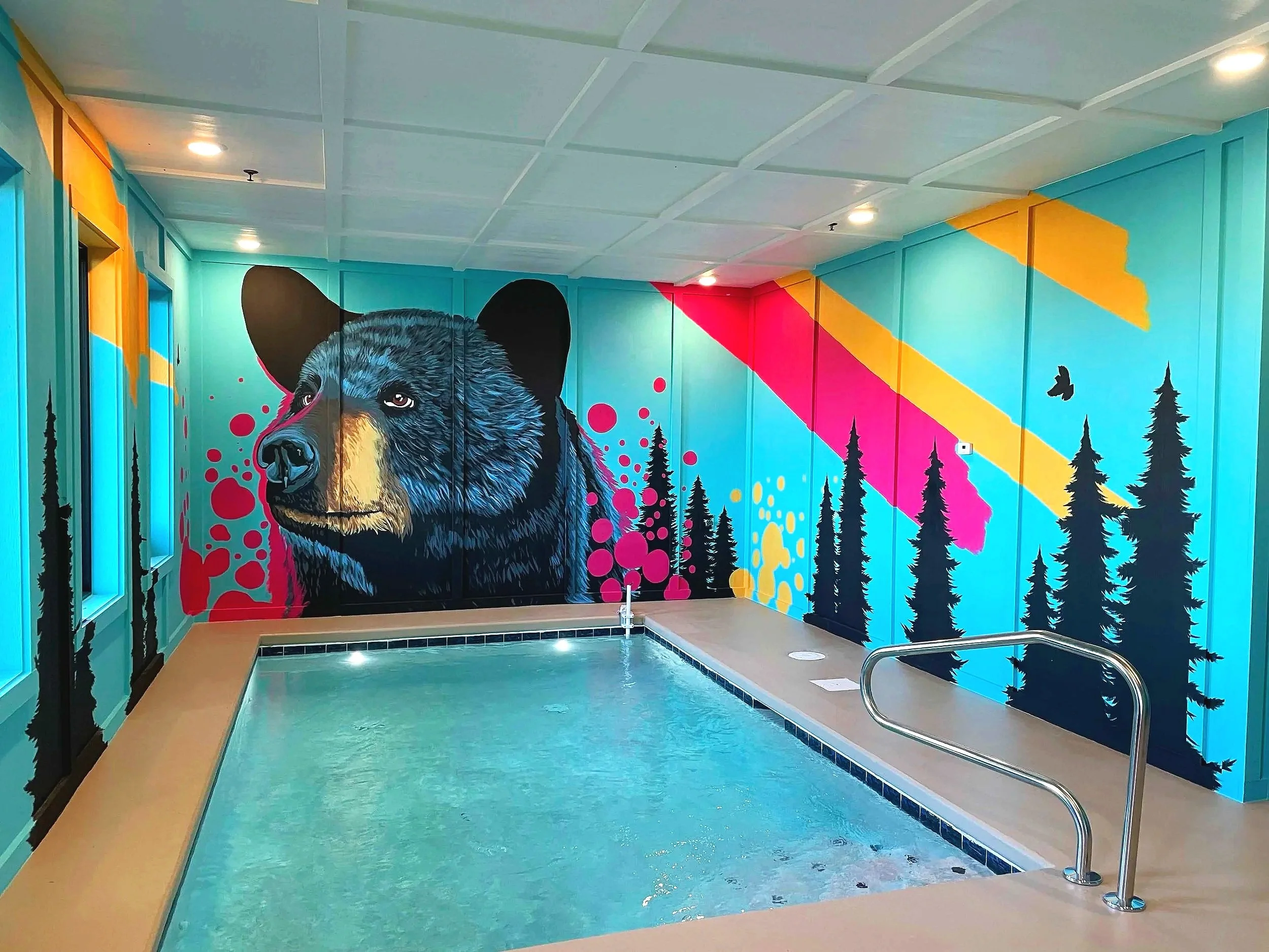 Vibrant pop-art black bear wall mural with forest silhouettes in a Smoky Mountains cabin.