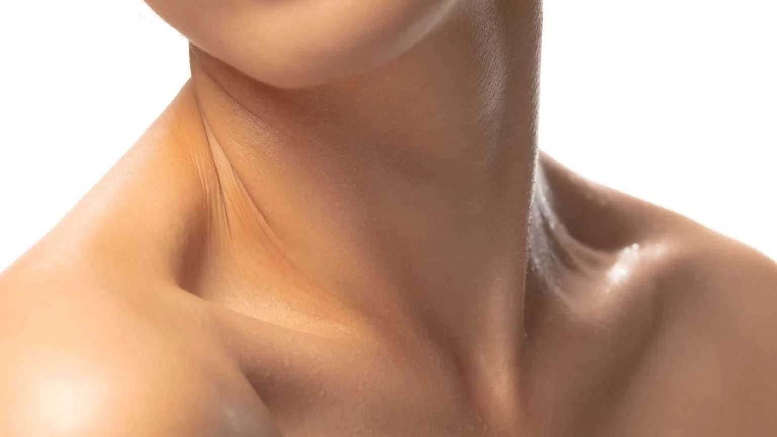 Close-up of a person's neck, shoulder, and lower face with smooth skin.