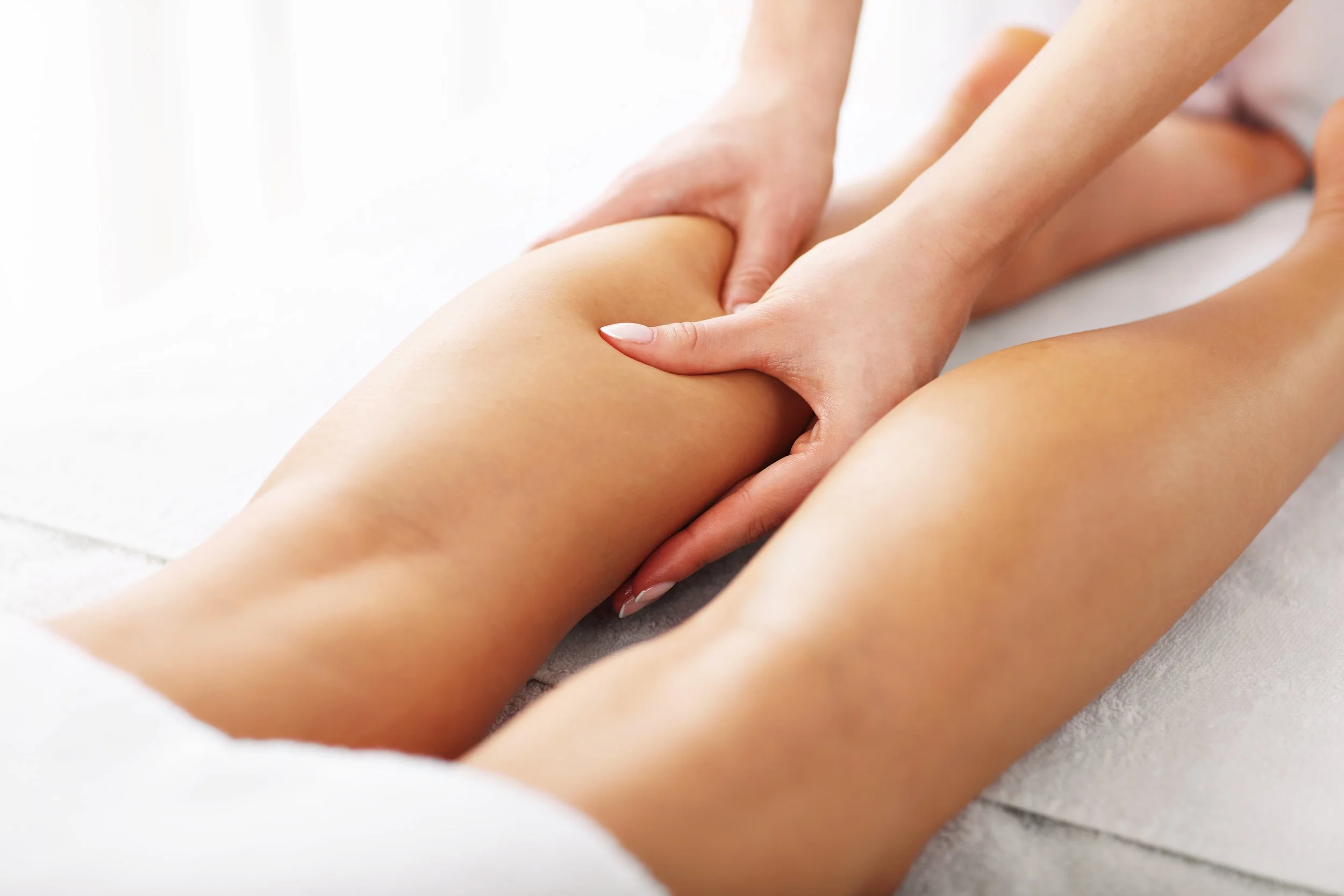 Person receiving a massage on their thigh from a massage therapist.