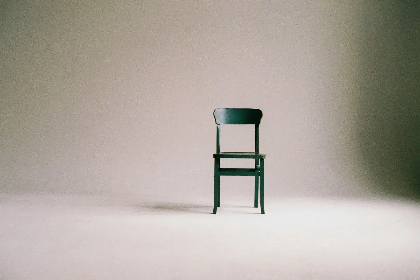 Chair sitting against a seamless backdrop in a studio setting.