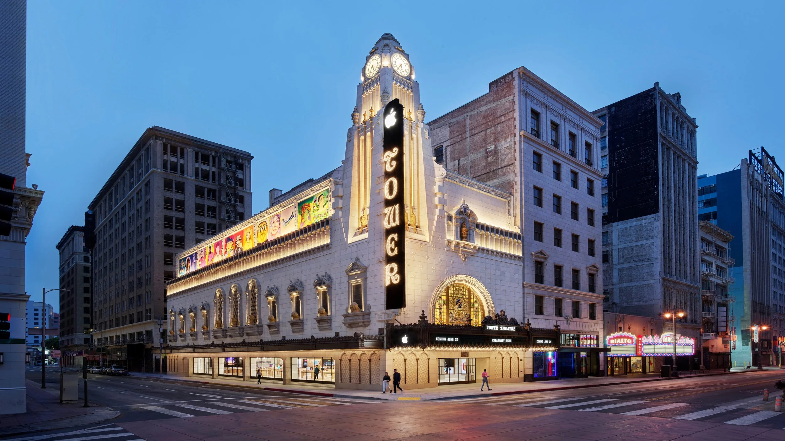 Nighttime exterior of the restored Tower Theatre, featuring large-scale art reproductions produced for Apple’s interior program.