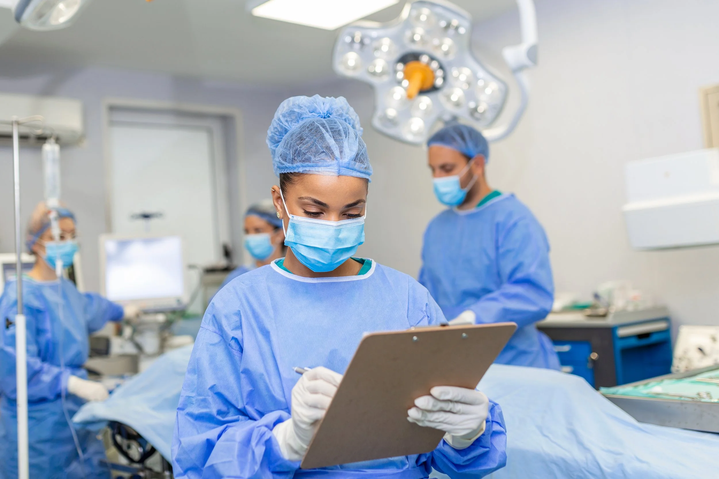 surgeon writing in clipboard during operation