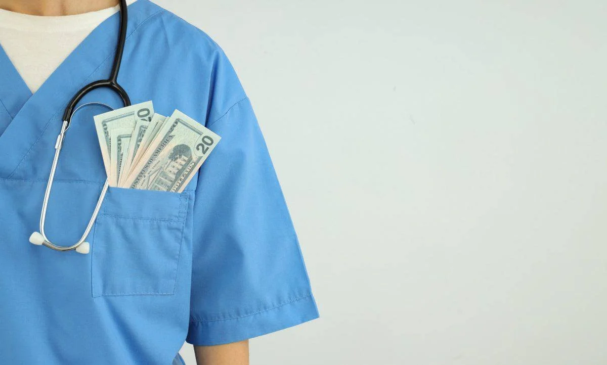 Photo of a healthcare person with money shown on her pockets