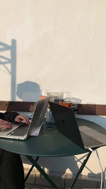 Two laptops on a small cafe table, symbolizing collaboration