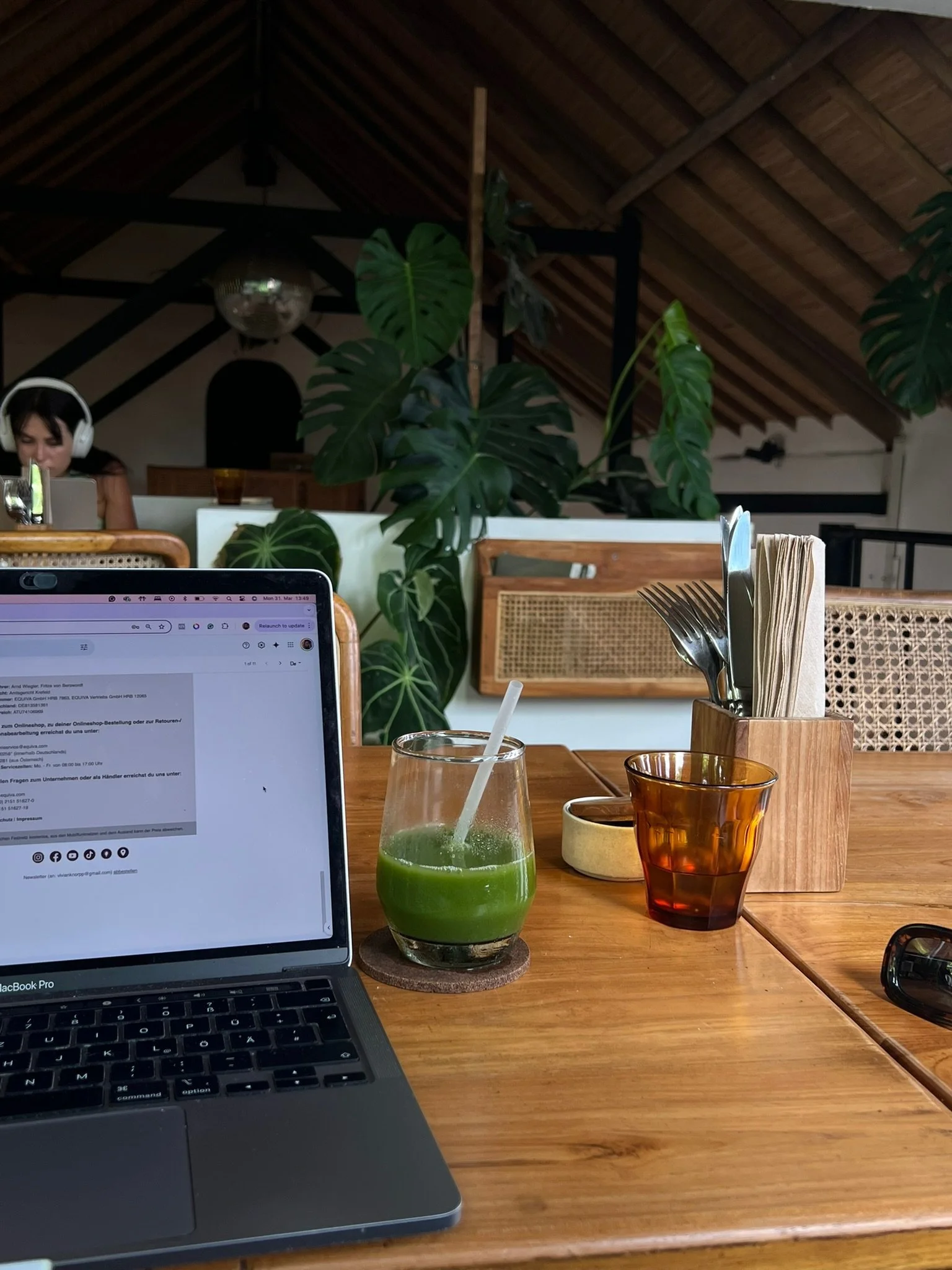 A laptop setup on a desk with a glass of matcha and water next to it, showcasing a healthy and balanced freelance lifestyle